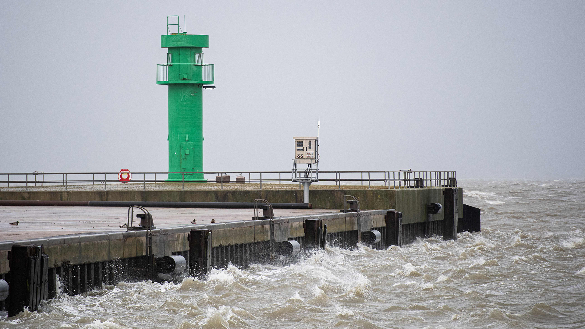 Wellen und Gischt der Nordsee treffen während auf die Hafenmole in Büsum. | AFP