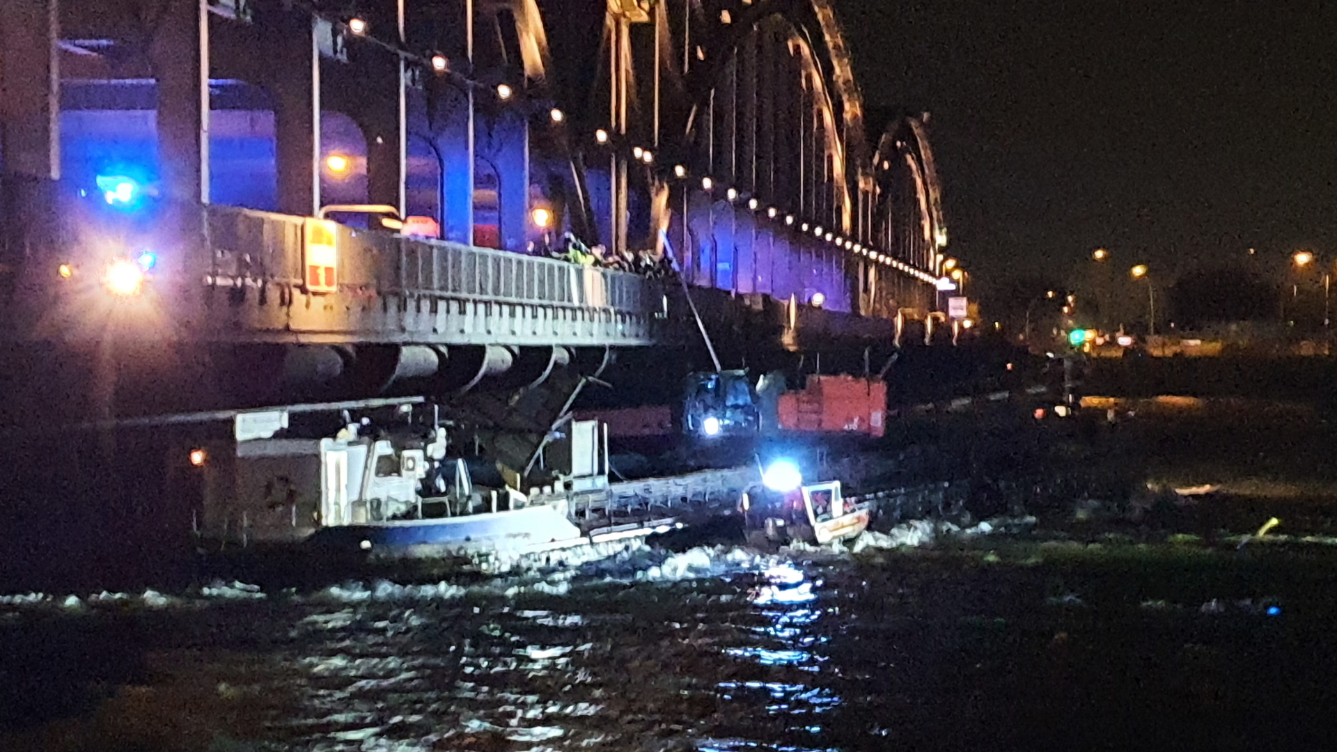 Einsatzkräfte der Polizei und Feuerwehr kommen zu einem Unfallort, nachdem sich ein Binnenschiff unter einer Brücke in Hamburg festgefahren hat. | dpa