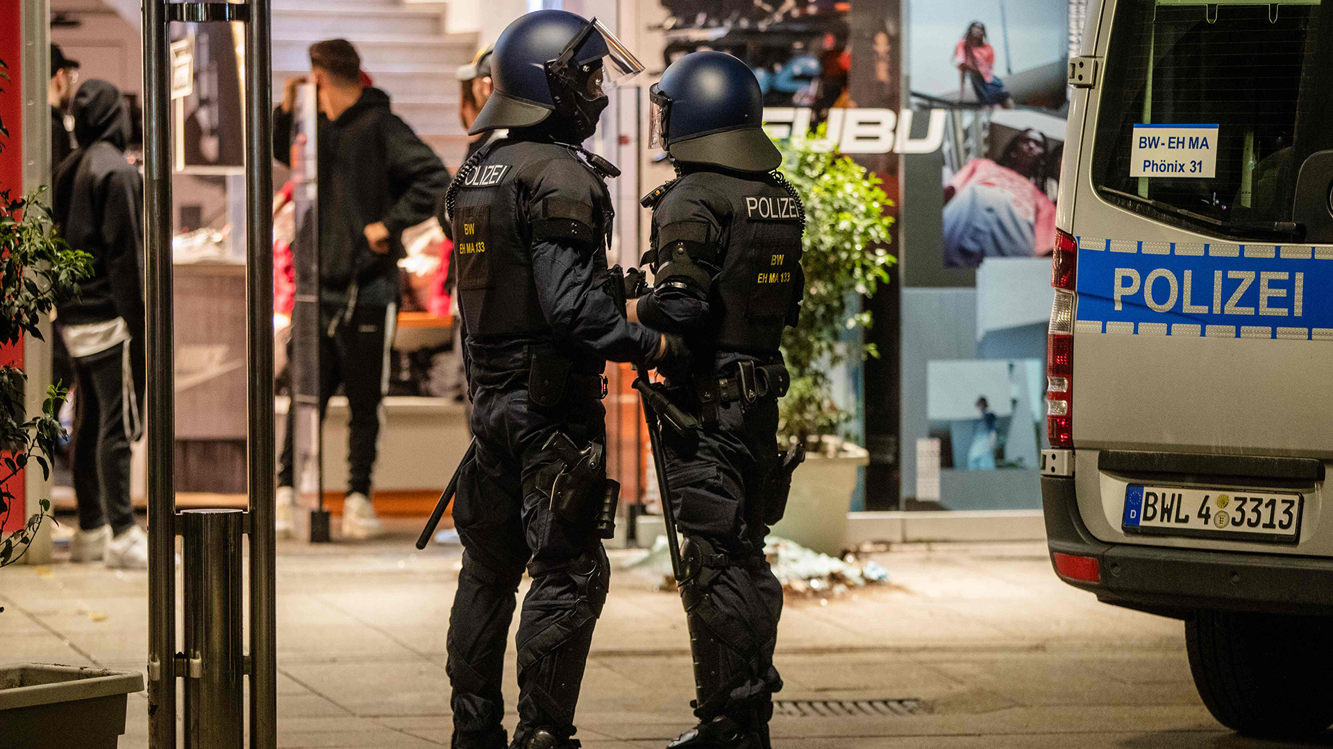 Polizisten stehen vor einem zerstörten Geschäft in Stuttgart | Bildquelle: AFP