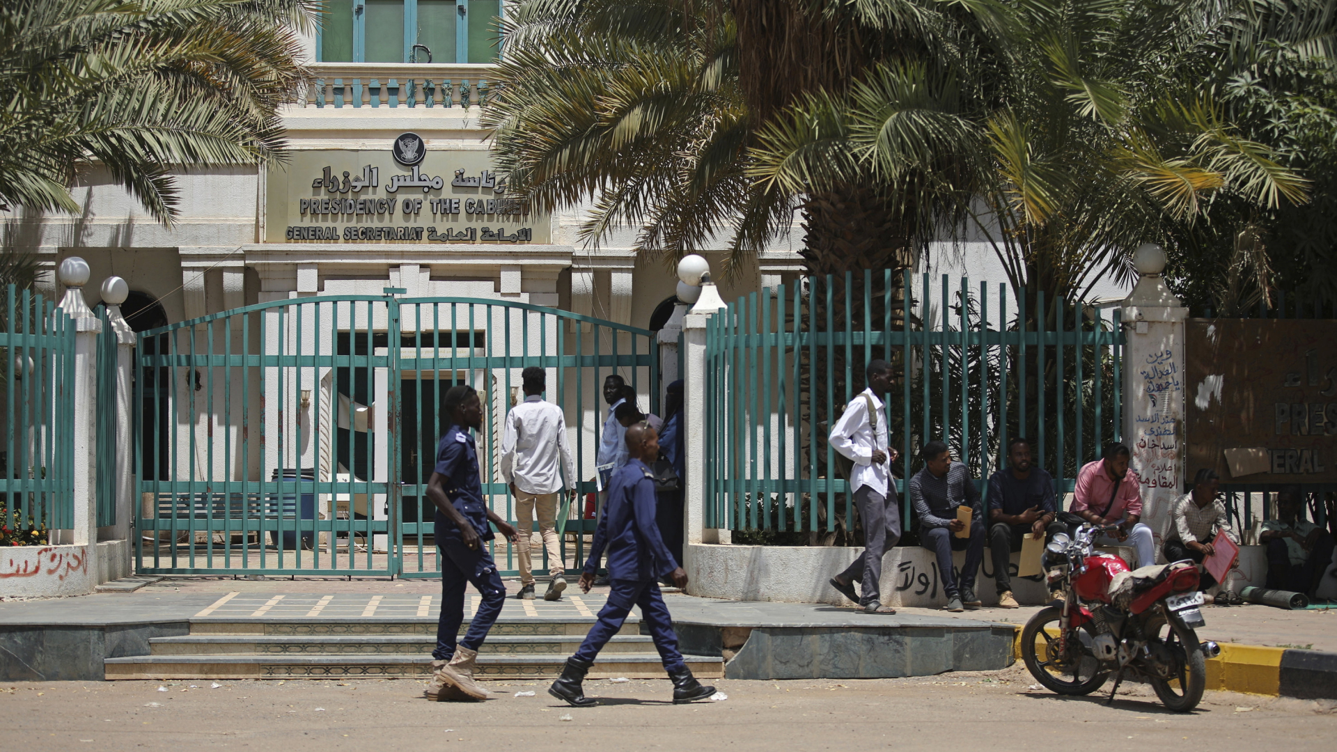 Mehrere Personen stehen vor einem sudanesischen Regierungsgebäude. | AP