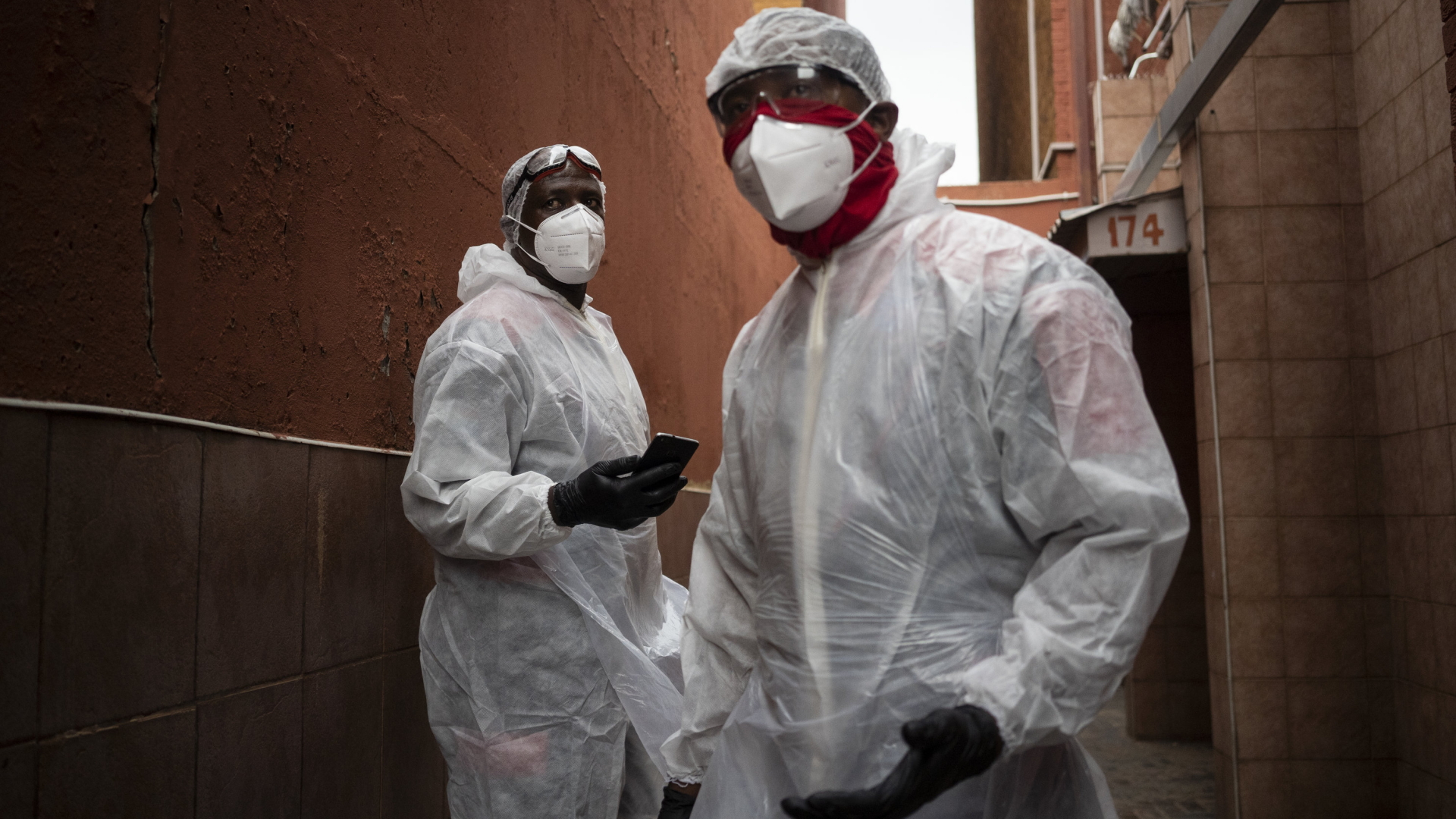 Zwei medizinische Mitarbeiter in Pretoria tragen eine komplette Schutzmontur gegen eine Ansteckung mit dem Coronavirus. | AP