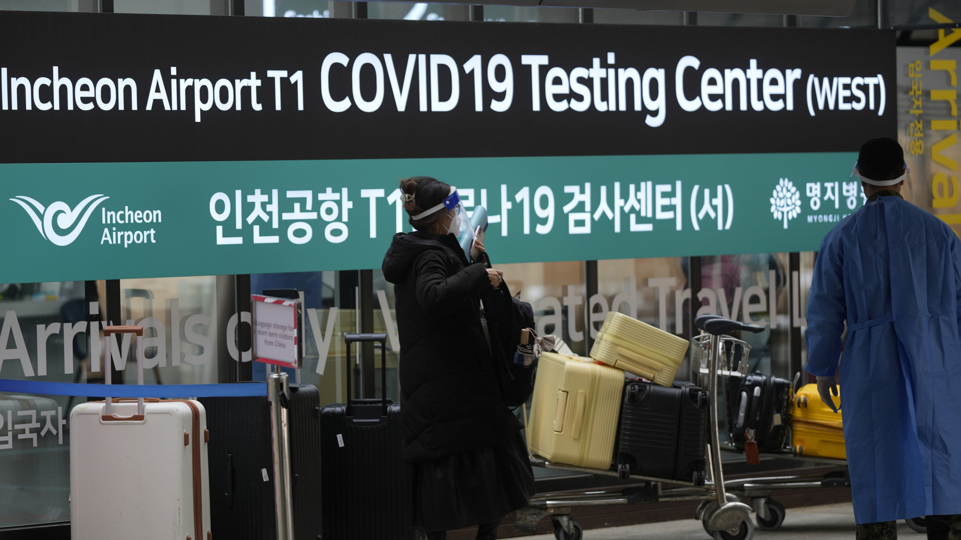 Eine Frau aus China wartet an einem Testzentrum am Flughafen Incheon in Südkorea. | AP