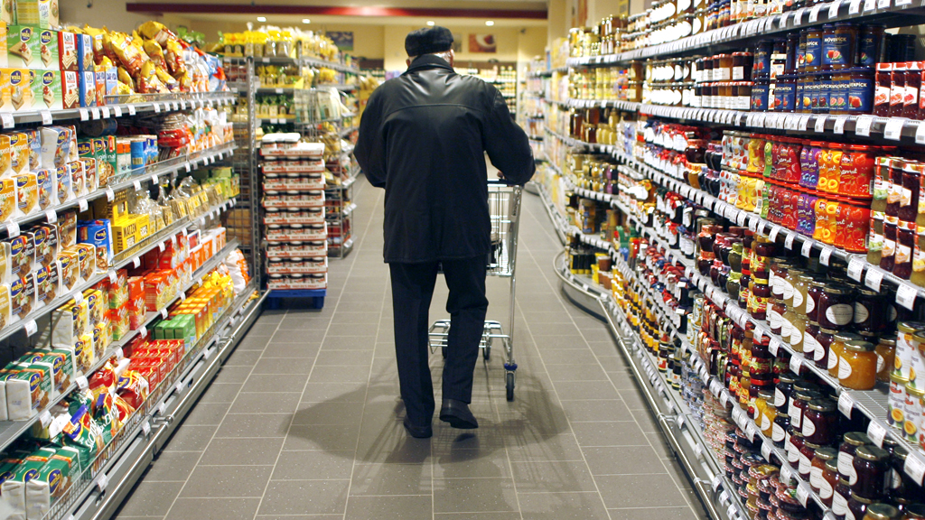Mann schiebt Einkaufswagen durch einen Supermarkt | null