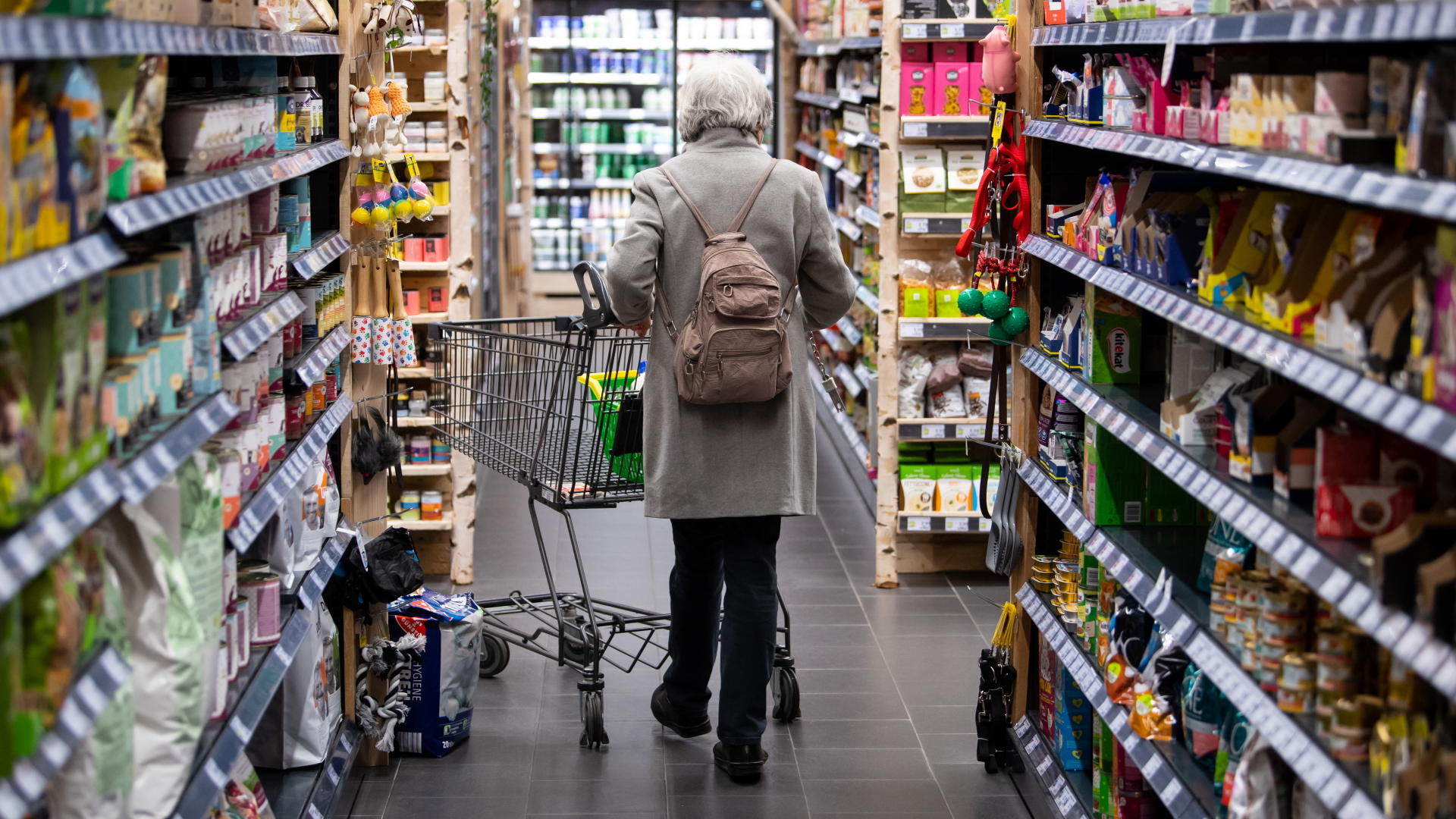 Eine Frau schiebt einen fast leeren Einkaufswagen durch einen Supermarkt im bayerischen Neubiberg. | dpa