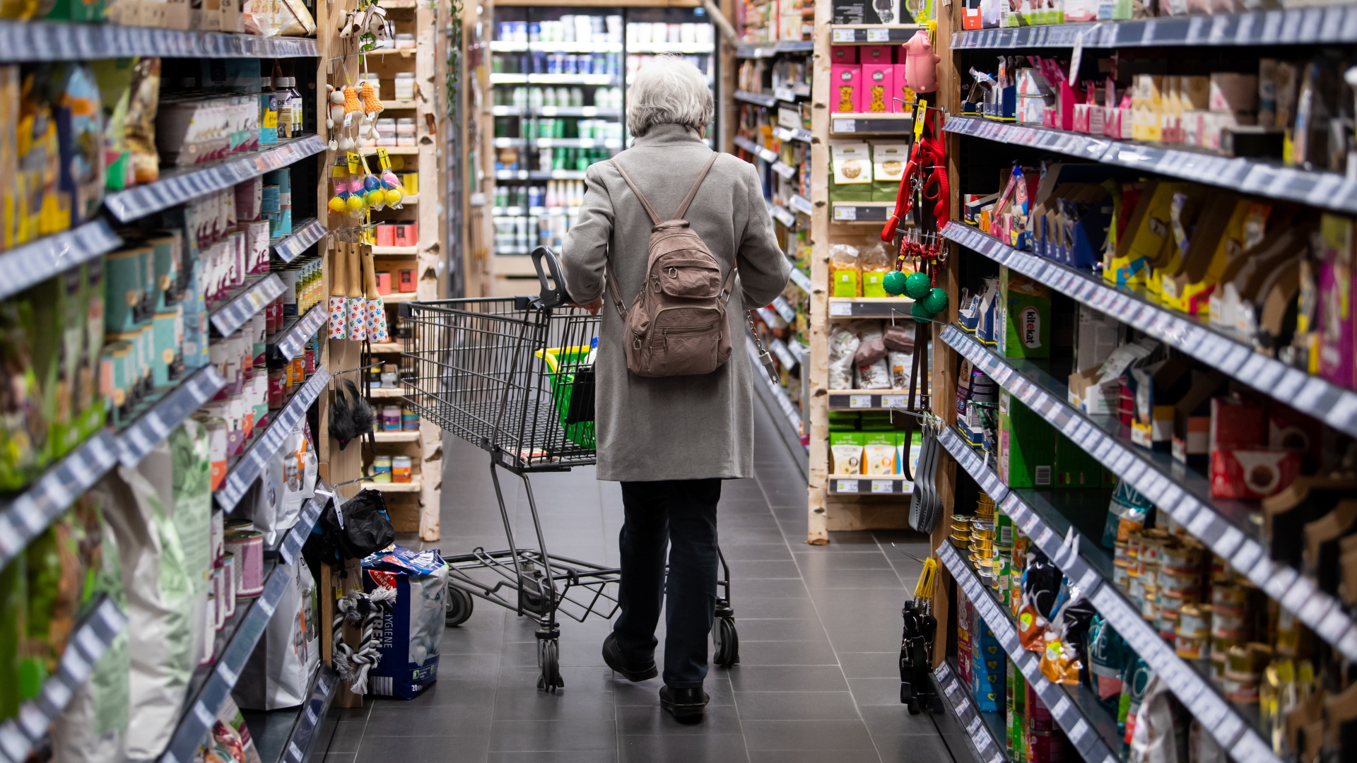 Eine Frau geht mit ihrem Einkaufswagen durch einen Supermarkt.  | dpa