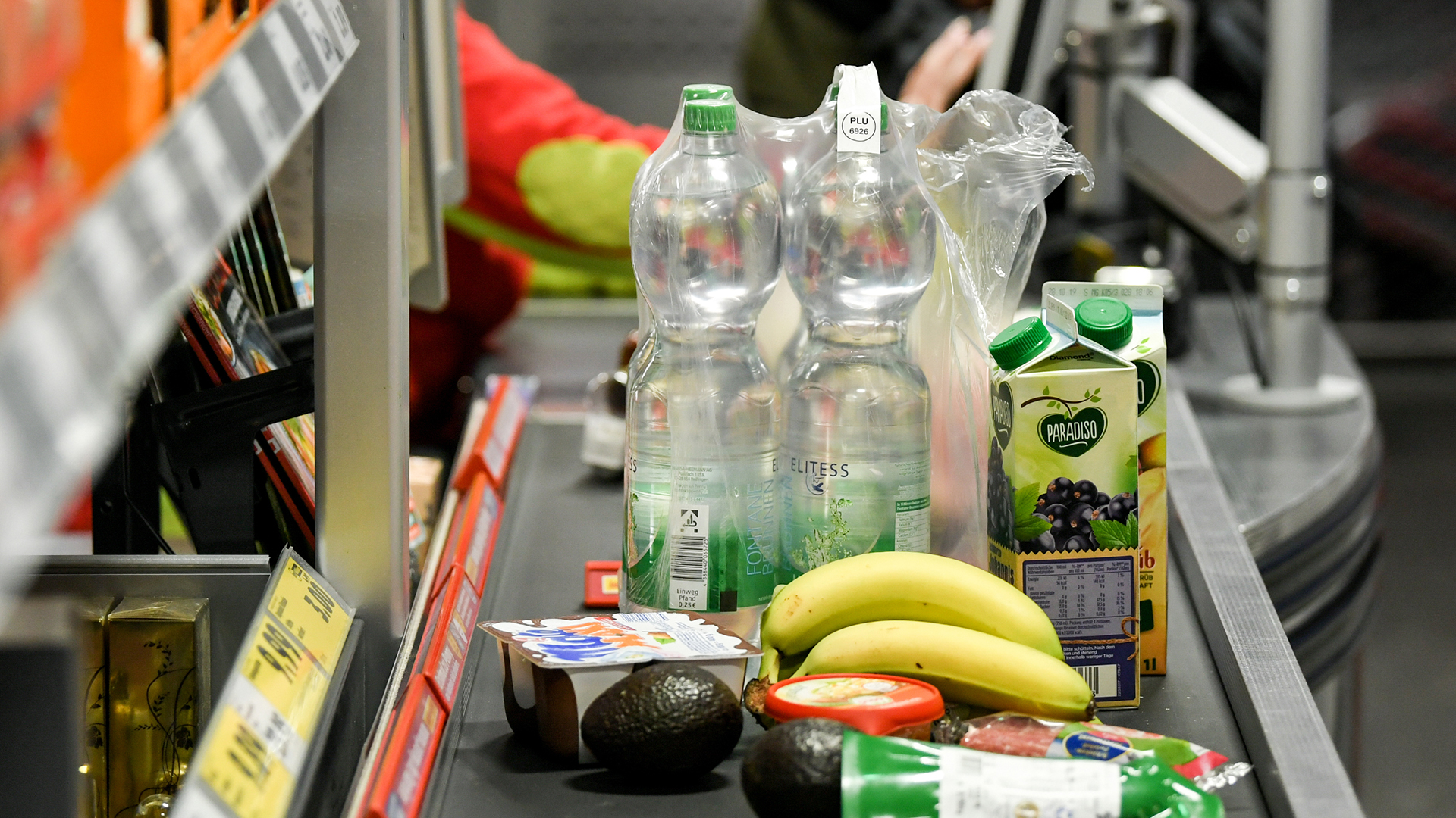 Lebensmittel liegen auf dem Band an einer Kasse in einem Supermarkt. 