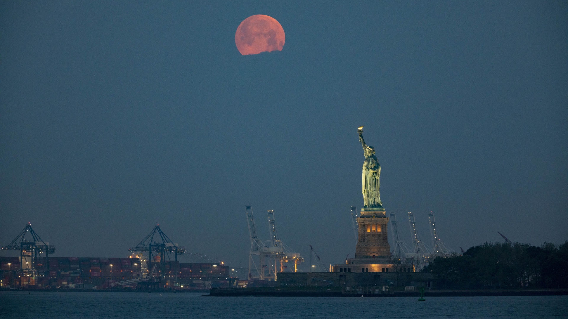 Ein Mond steht über der Freiheitsstatue in New York.  | dpa