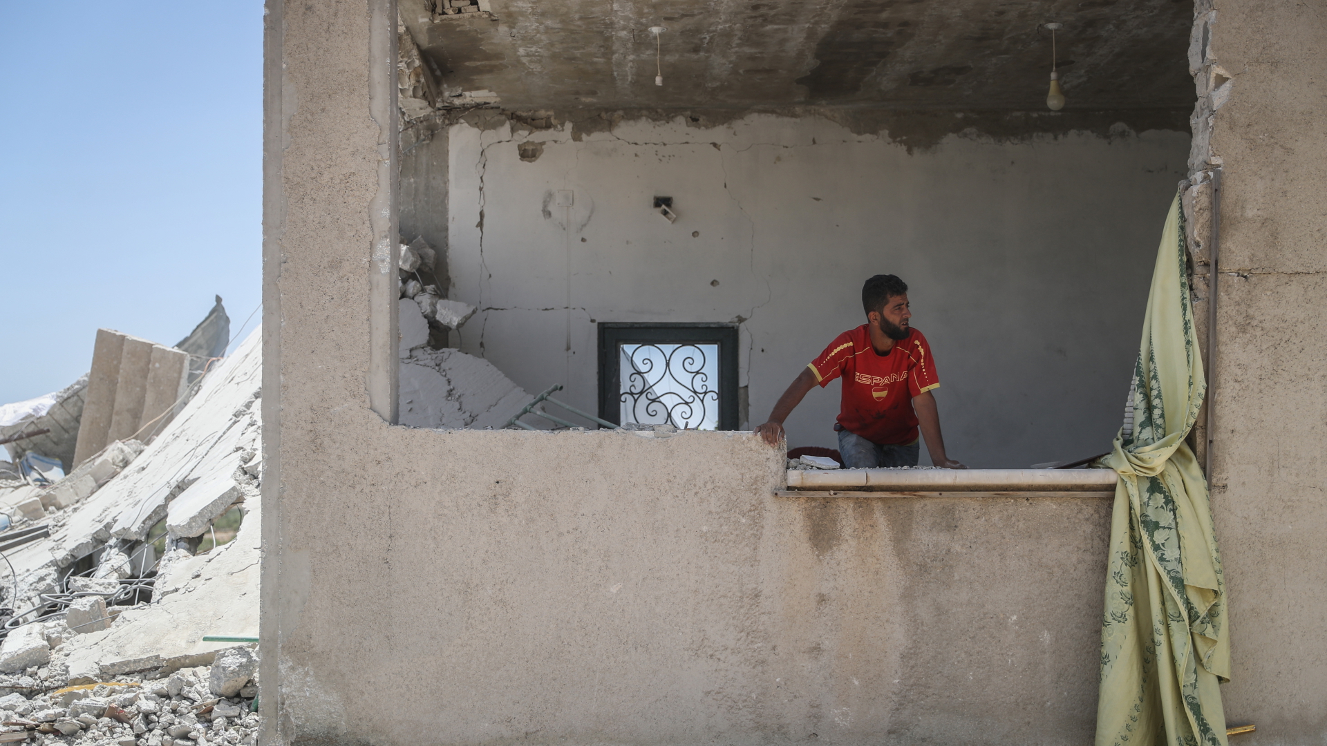 Ein Mann steht in einem zerstörten Haus in der syrischen Stadt Balyun. | dpa