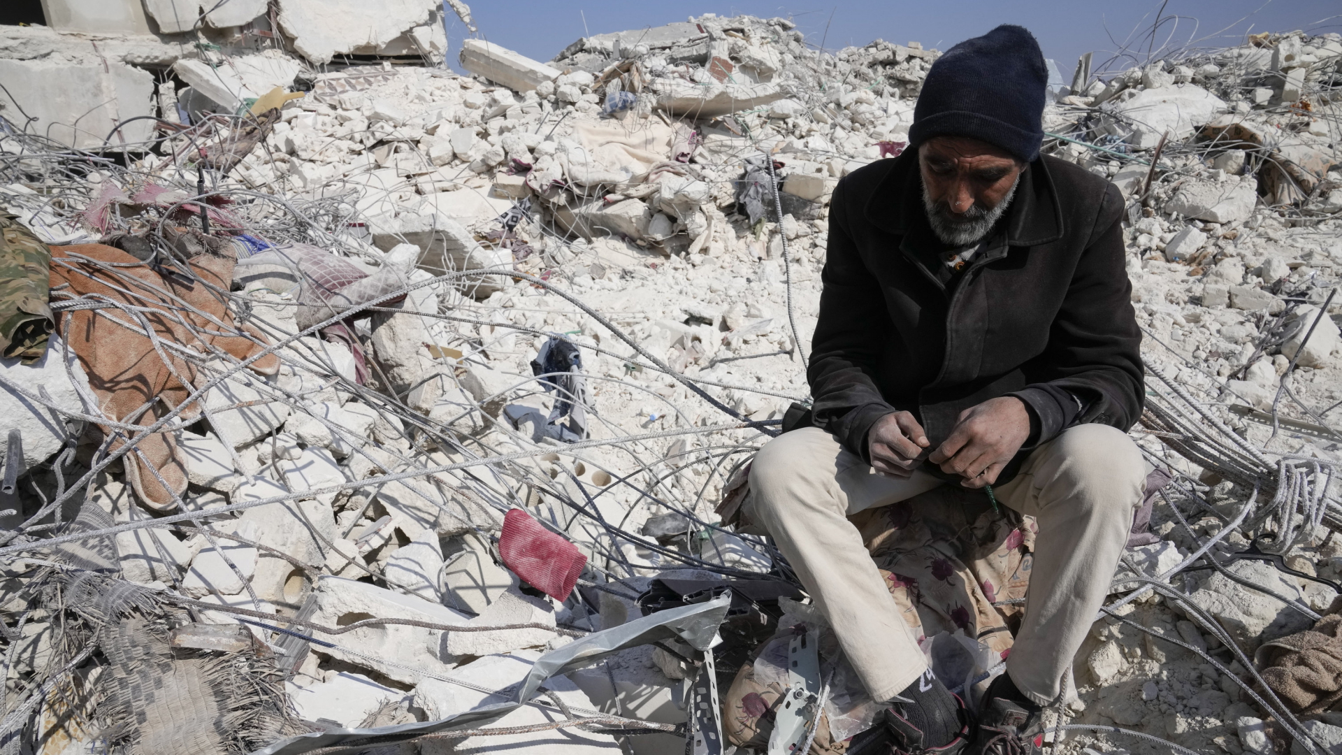 Ein Mann sitzt auf den Trümmern eines zerstörten Hauses in der syrischen Stadt Atareb. | AP