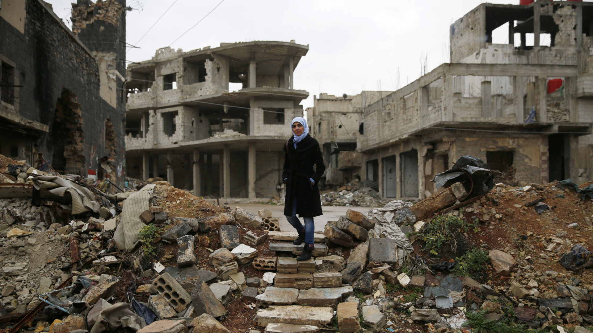 Eine Frau läuft durch Trümmer in der syrischen Stadt Homs | AP