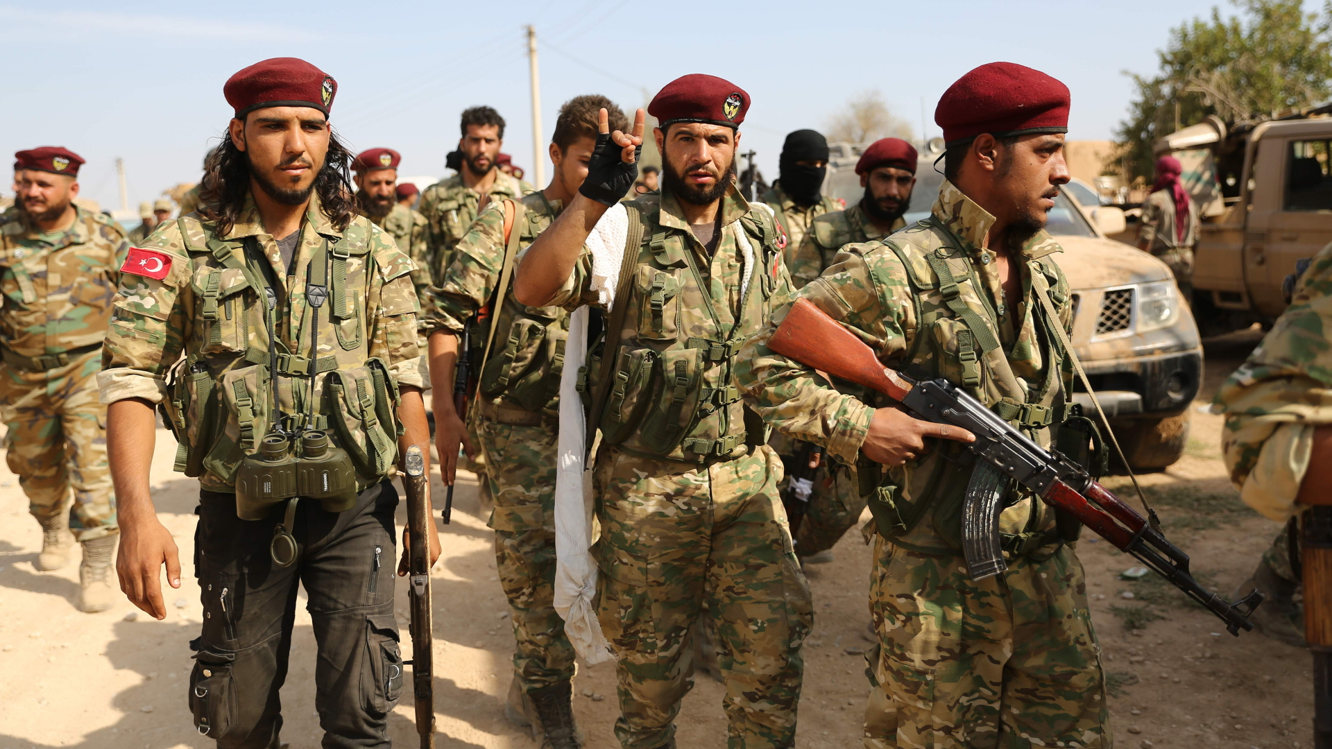 Pro-türkische Kämpfer marschieren durch die strategisch wichtige Grenzstadt Ras al-Ain. | AFP