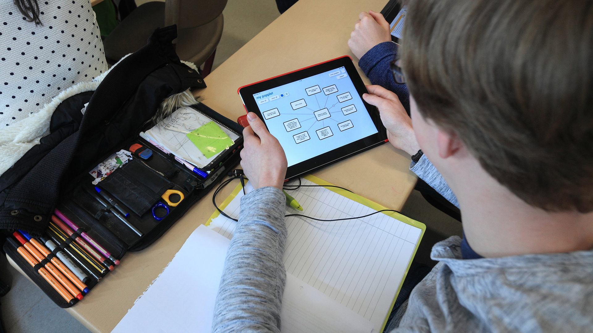 Mit einem speziellen Tablet arbeitet ein Schüler im Unterricht