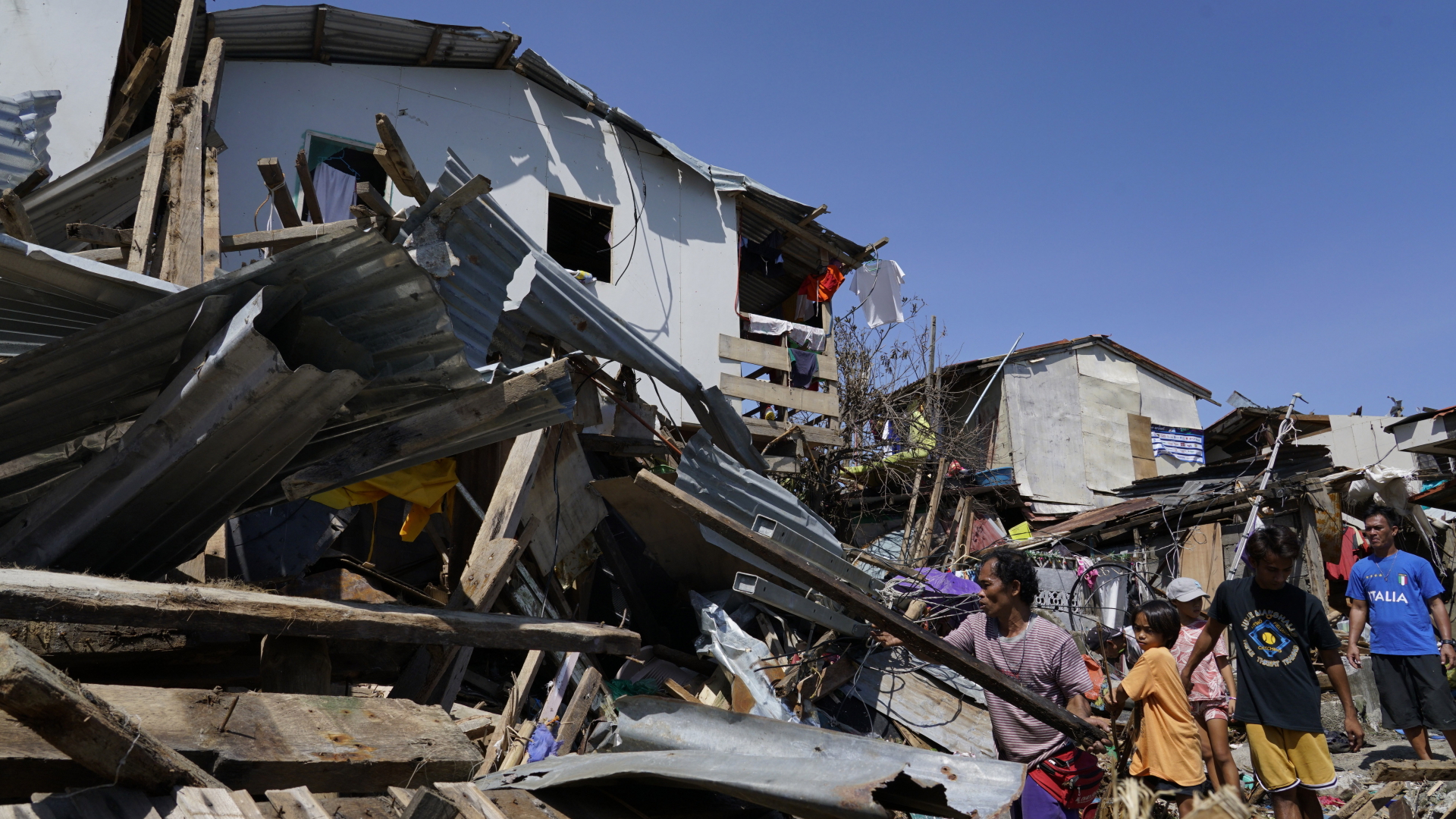 Bewohner suchen nach Habseligkeiten in den Trümmern von zerstörten Häusern. | dpa