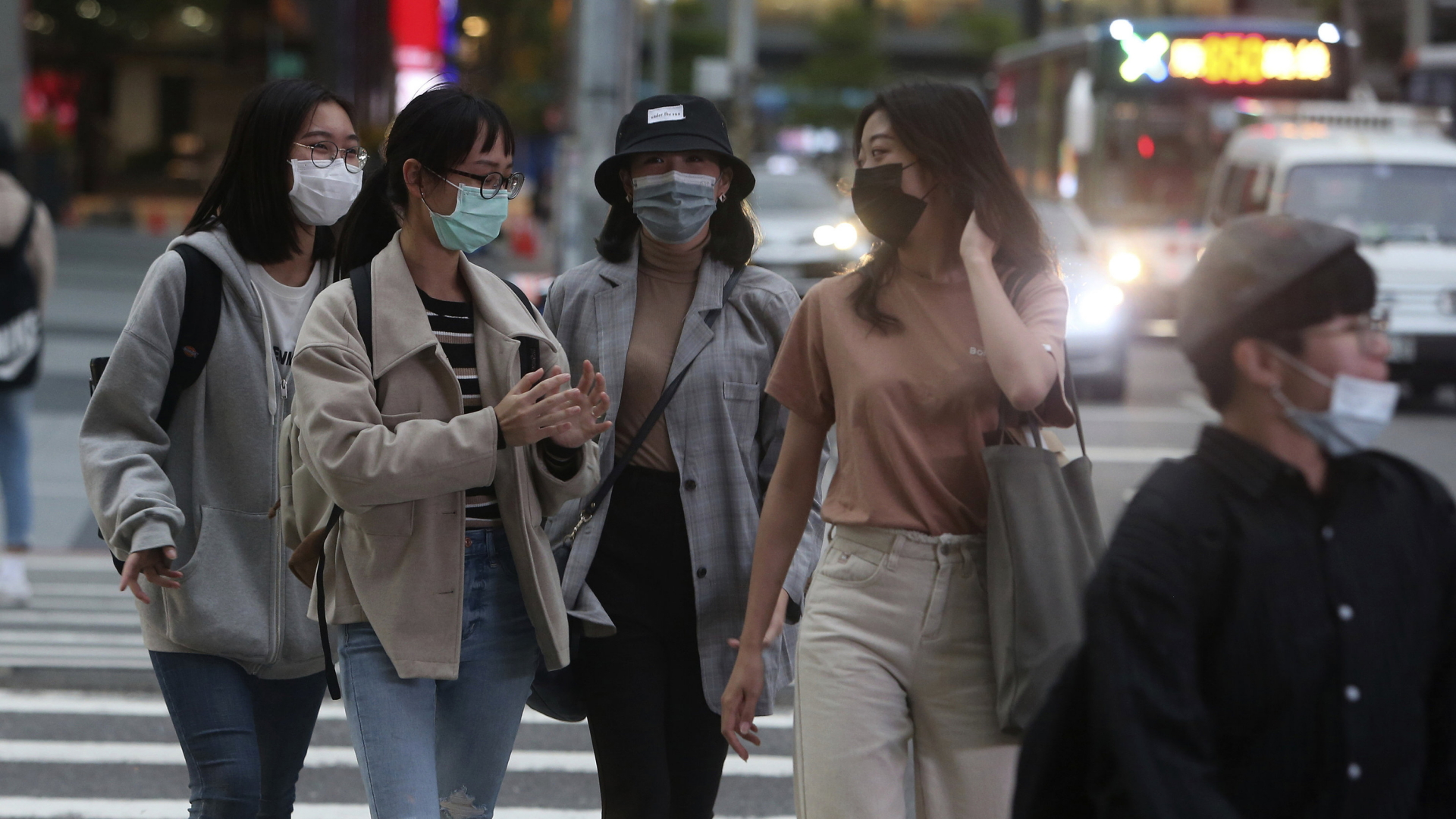 Junge Frauen auf der Straße in Taipeh. Sie tragen Masken, um sich vor dem Coronavirus zu schützen. | AP
