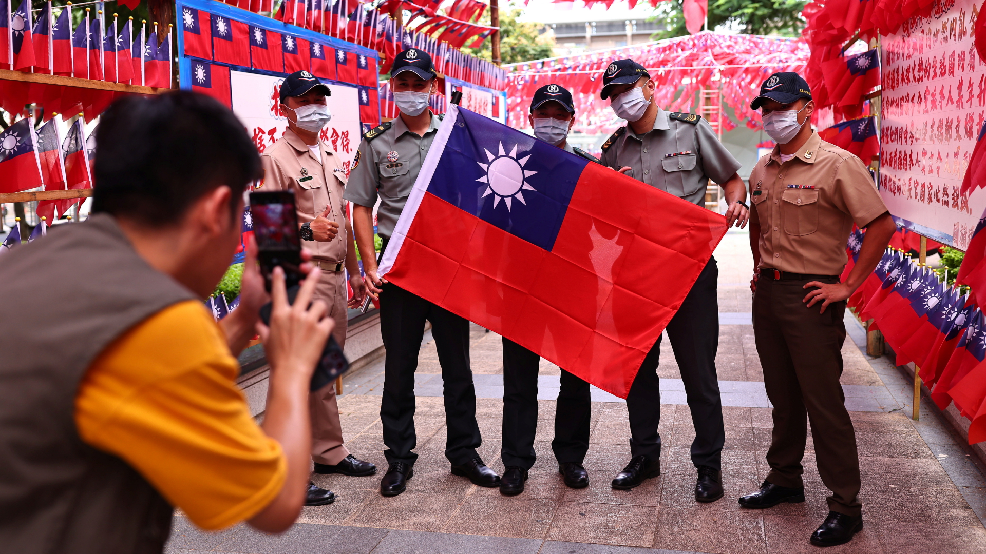 Soldaten posieren mit einer Taiwan-Flagge vor roten Girlanden, die anlässlich des Nationalfeiertags in Taipeh angebracht sind. | REUTERS