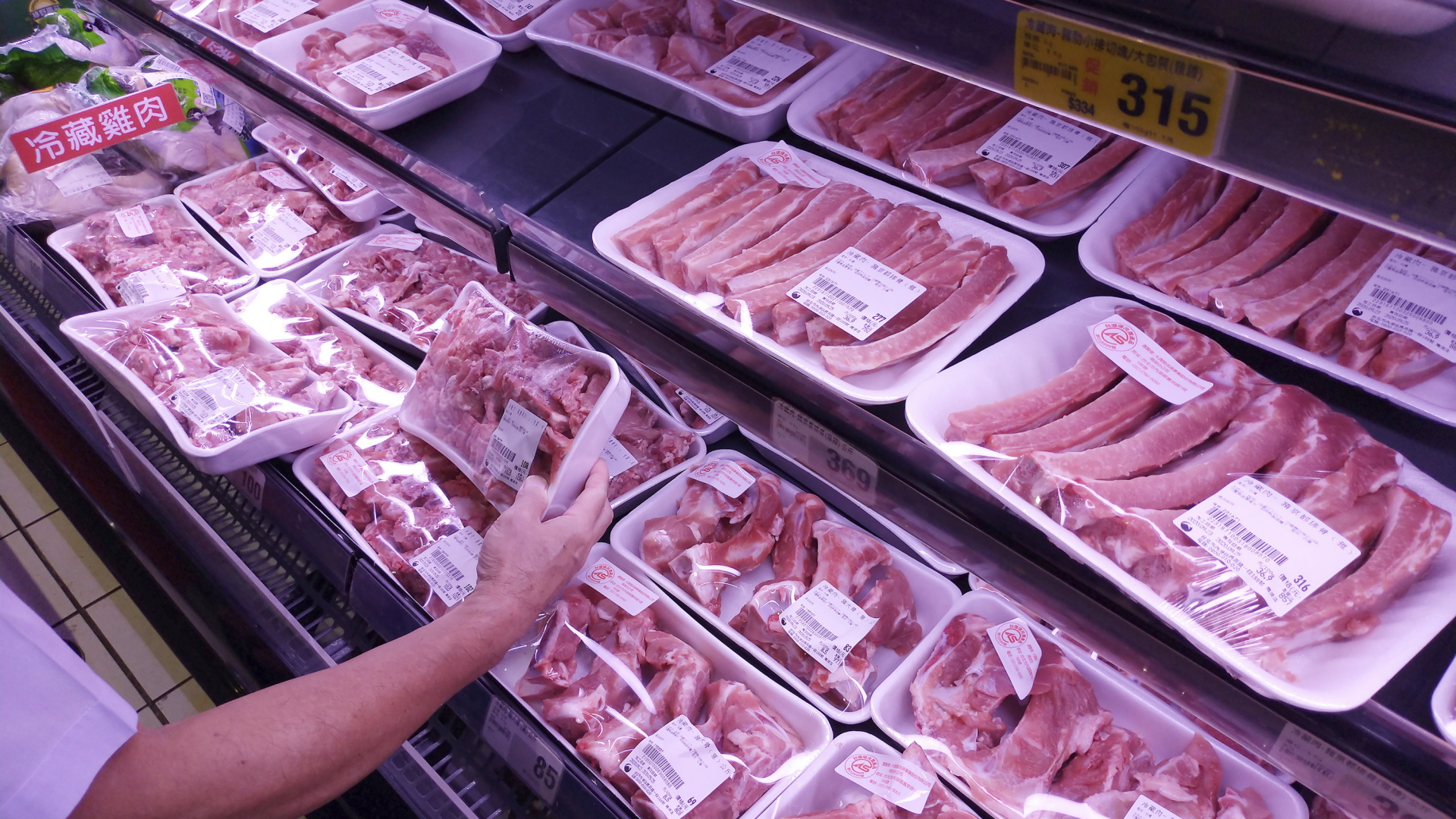Eine Hand greift nach einer Fleischpackung in einem Supermarkt in Taiwan | AP