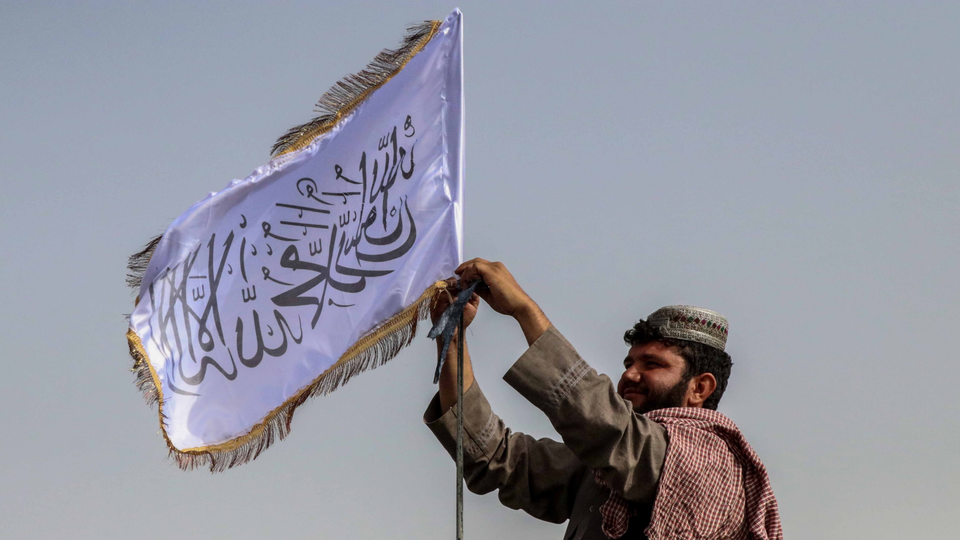 Ein Mann hisst in Kandahar (Afghanistan) die Flagge der Taliban | EPA
