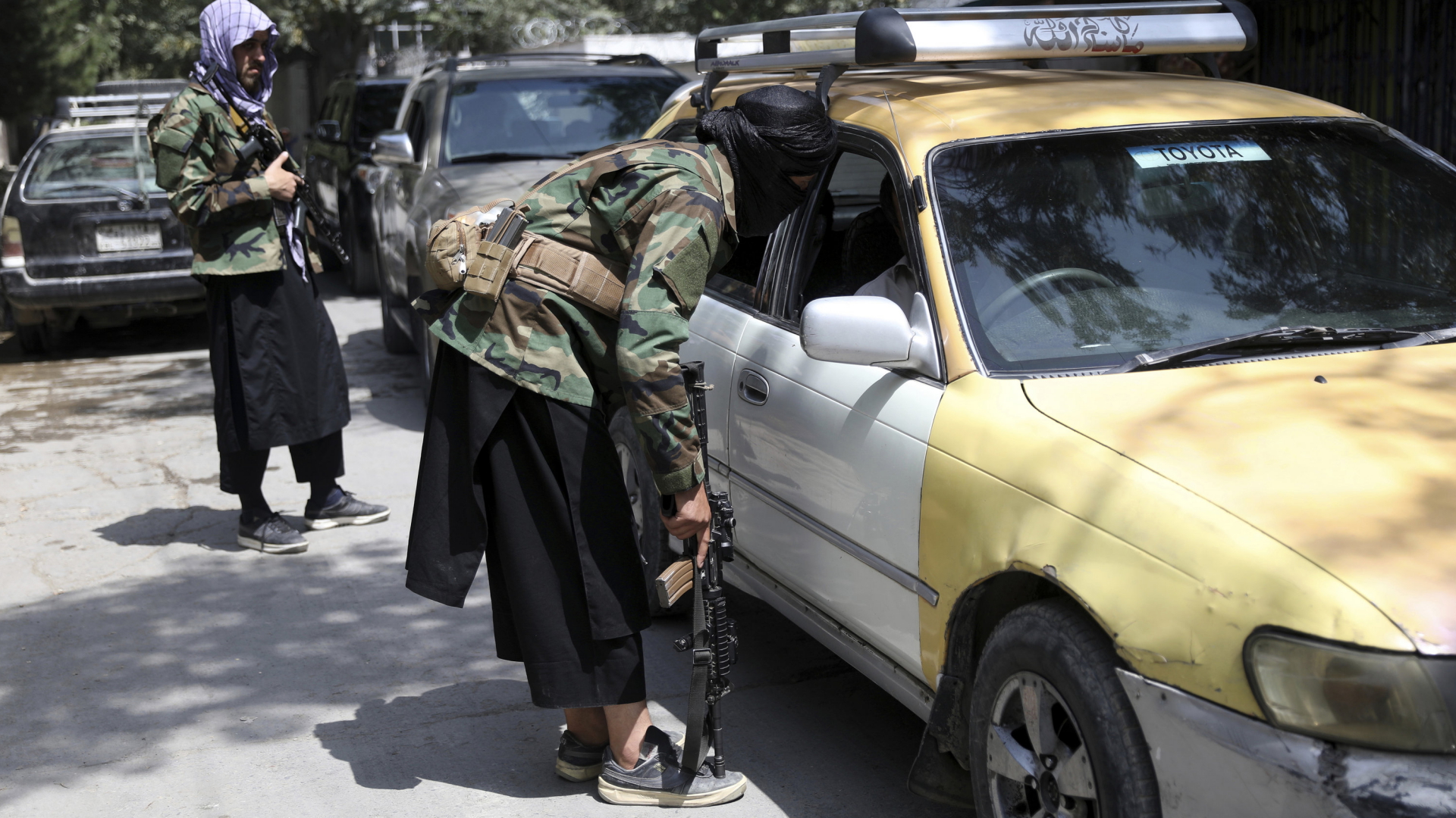 Kämpfer der Taliban befragen an einem Kontrollpunkt in Kabul Autofahrer. | AP
