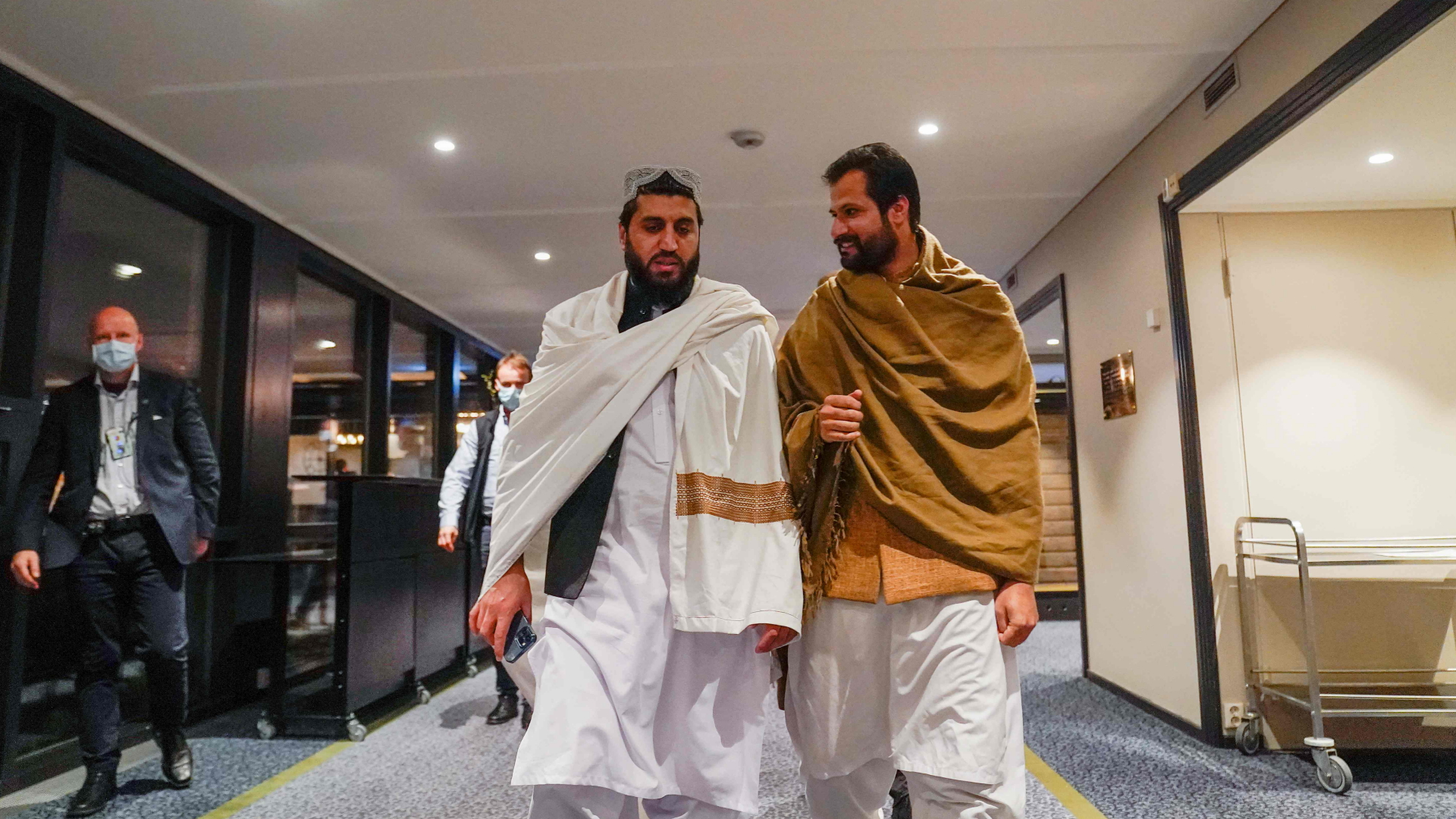 Vertreter der Taliban gehen einen Hotelflur in Oslo entlang. | AFP