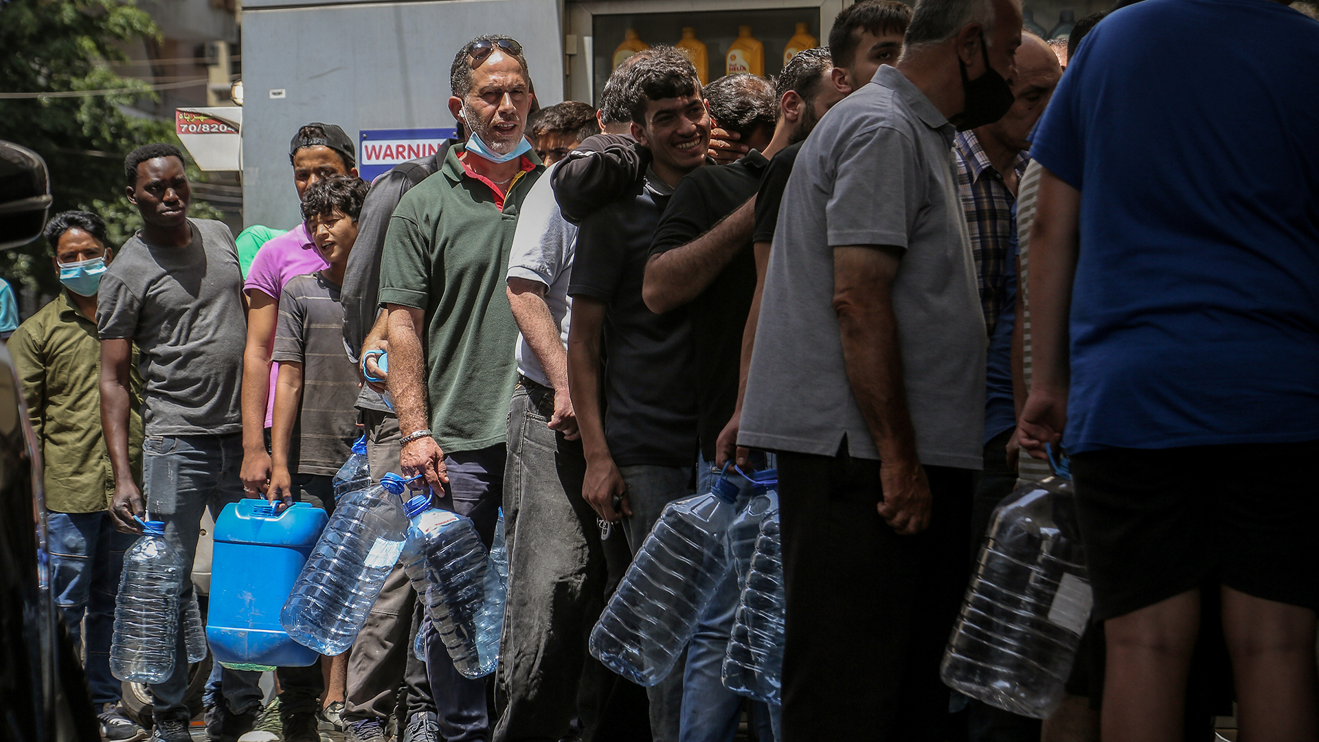 Menschen mit Plastikgallonen warten in der Schlange an einer Tankstelle in Beirut.  | dpa