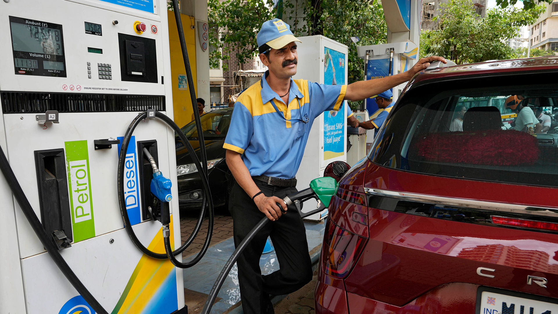 Ein Mitarbeiter einer Tankstelle füllt Benzin in ein Fahrzeug in Mumbai, Indien.  | AP