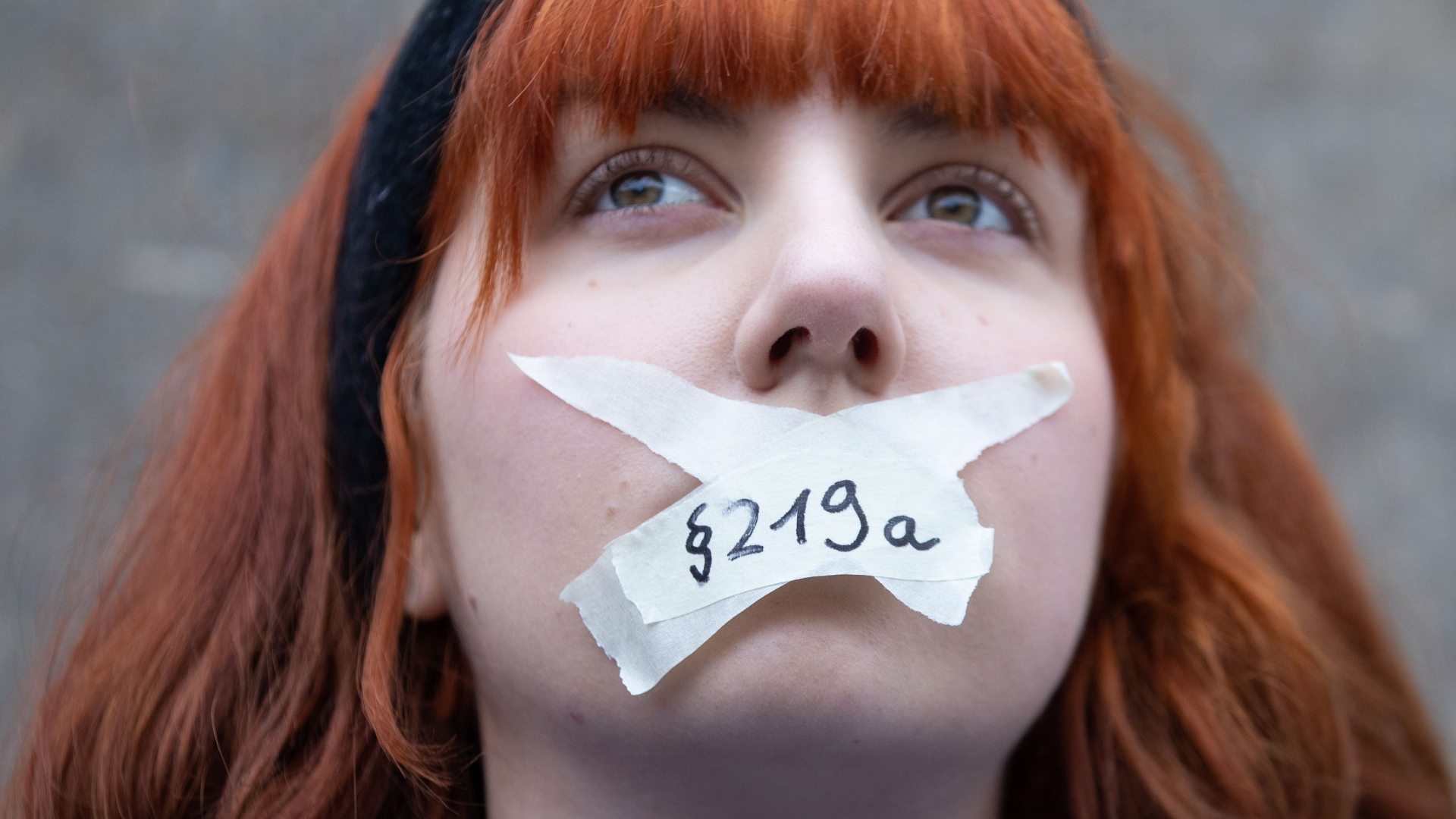 Eine Frau, die sich Klebebandstreifen mit der Aufschrift "219a" auf den Mund geklebt hat. | HAYOUNG JEON/EPA-EFE/REX