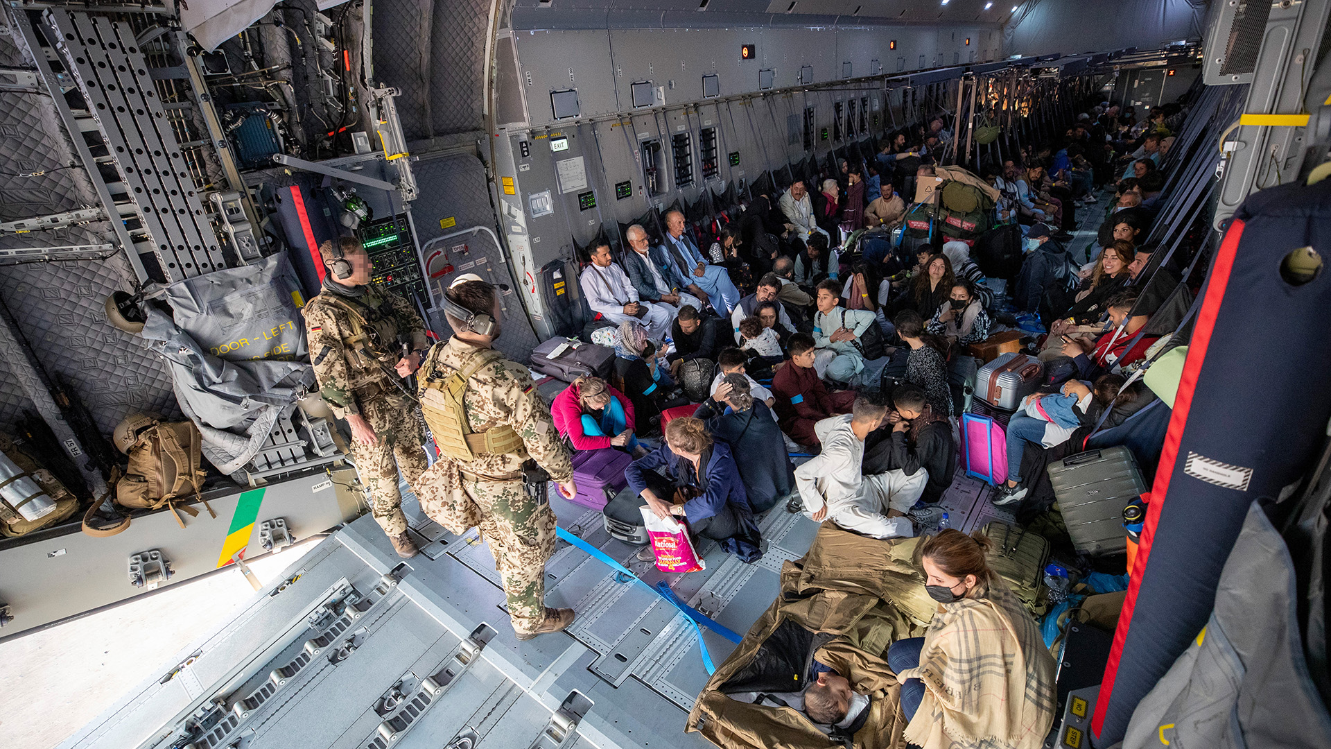 Aus Afghanistan geflohene Menschen sitzen in einer Transportmaschine der Luftwaffe. | Bundeswehr/Marc Tessensohn