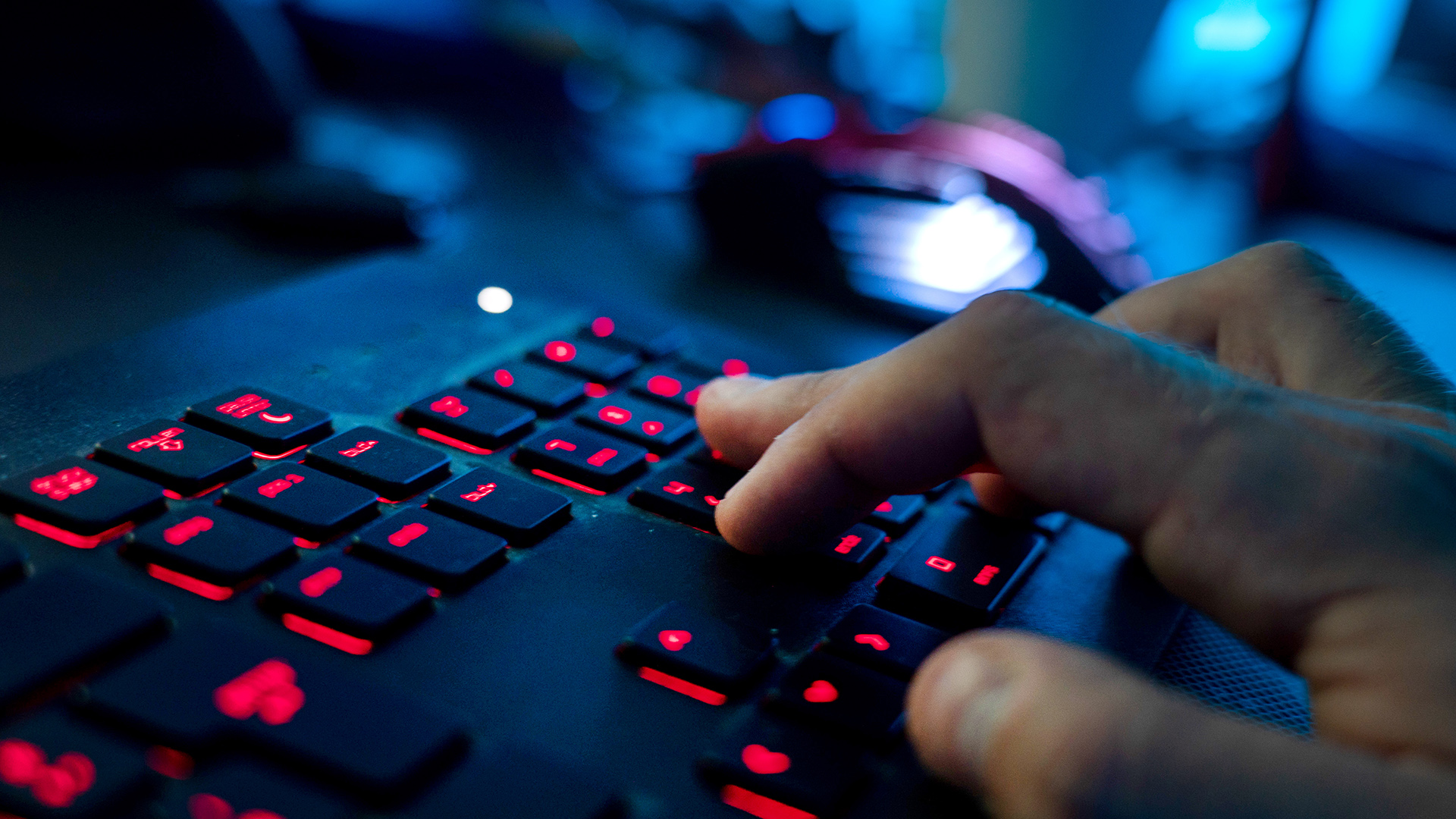 Ein Mann sitzt am Rechner und tippt auf einer Tastatur. 
