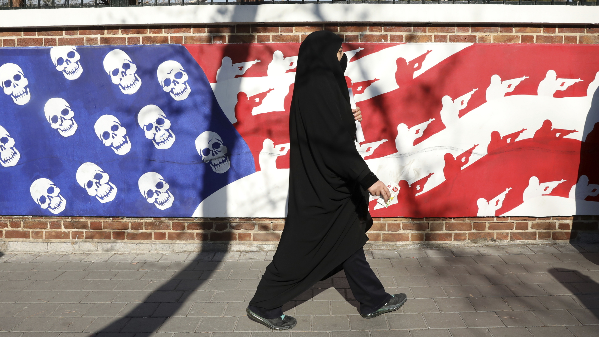 Eine Frau geht an einem anti-amerikanischen Wandbild in Teheran vorbei. | dpa