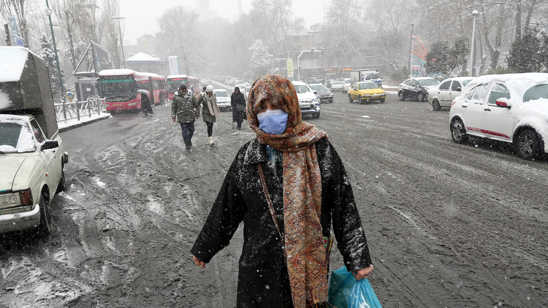 Verschneite Straße mit Menschen in Teheran. | AP