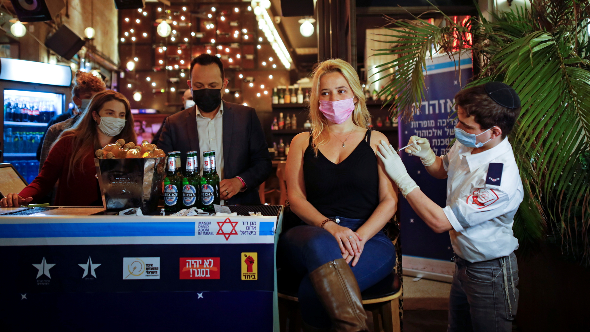 Eine Frau wird in einer Bar gegen das Coronavirus geimpft - Teil einer Kampagne, die Menschen dafür ein Freigetränk anbietet. | REUTERS