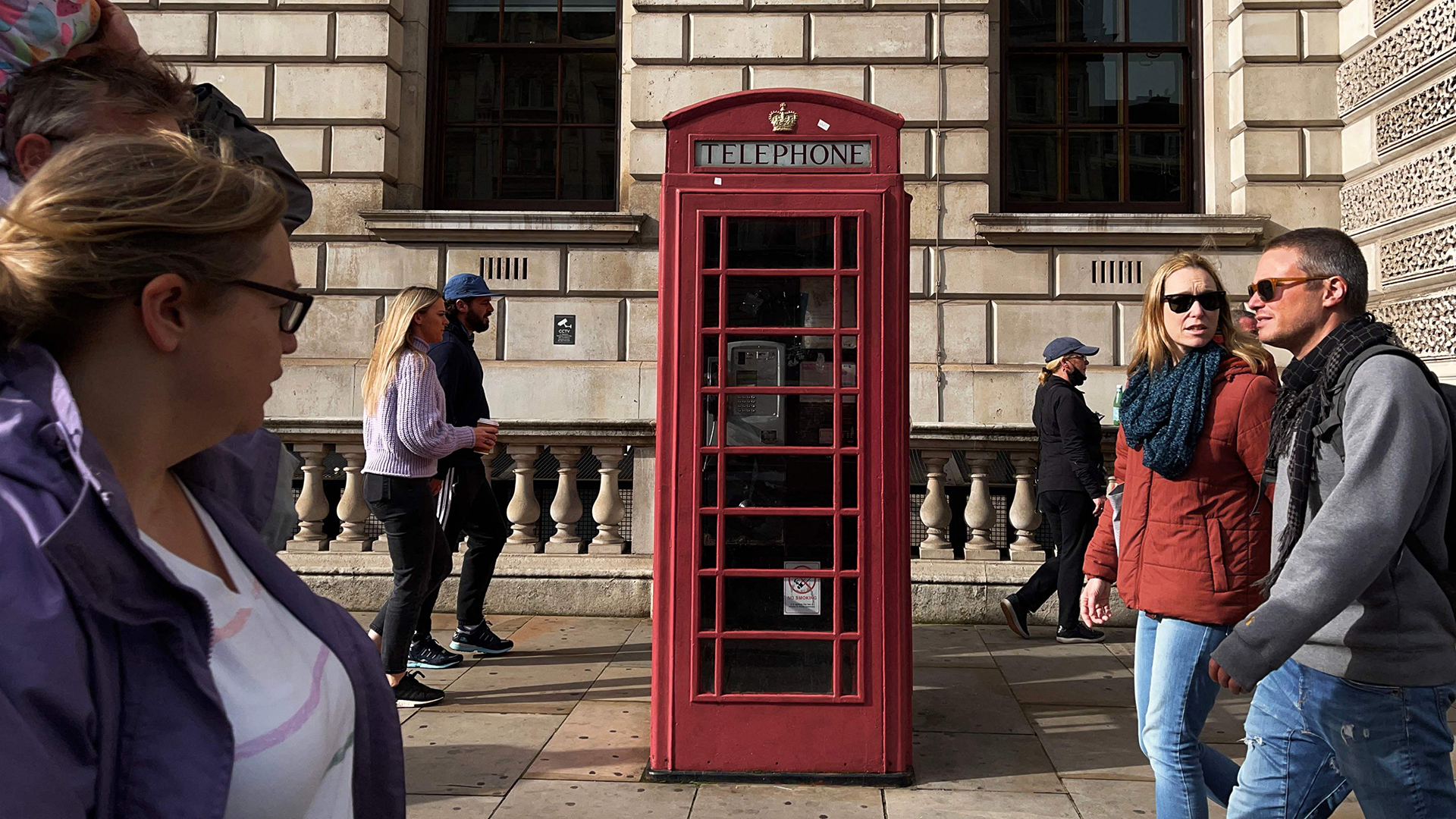 Fußgänger gehen im Zentrum Londons an einer roten Telefonzelle vorbei. | AFP