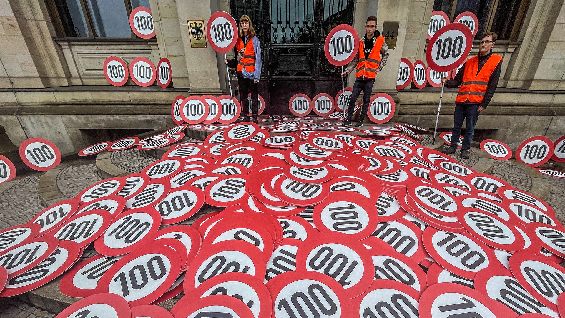 Mitglieder der Klimaschutz-Protestgruppe "Letzte Generation" mit mehr als 500 Tempo-100-Schildern vor dem Bundesverkehrsministerium Berlin. | dpa