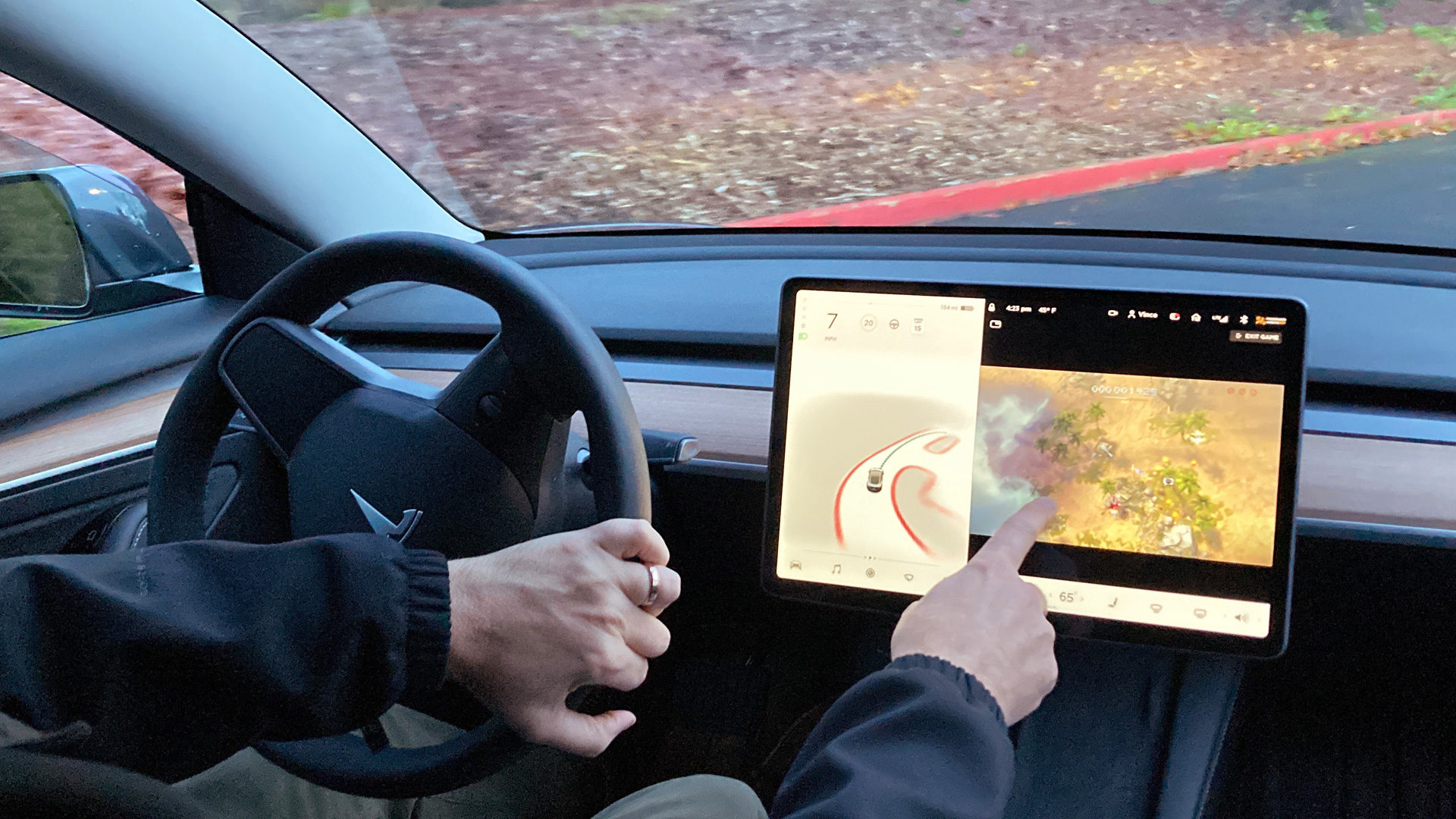 Ein Tesla-Besitzer, demonstriert wie er während der Fahrt Videospiele auf der Konsole des Fahrzeugs spielen kann.  | dpa