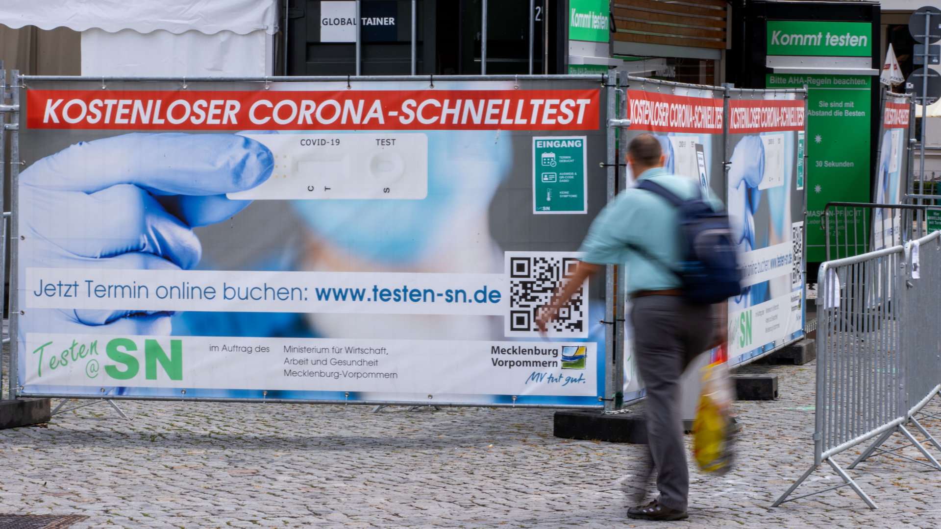 Ein Mann geht an einem Corona-Schnelltest-Zentrum in der Innenstadt von Schwerin vorbei | dpa
