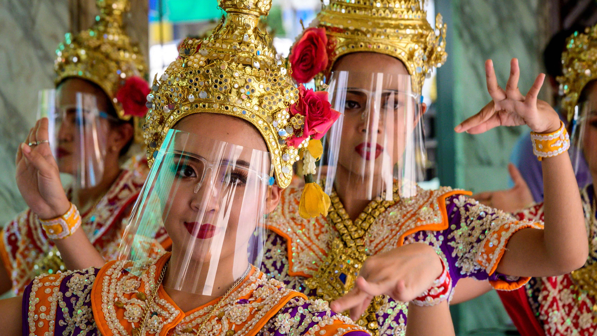 Thailändische Tänzerinnen in traditioneller Kleidung tragen Gesichtsvisiere zum Schutz vor dem Coronavirus. | AFP
