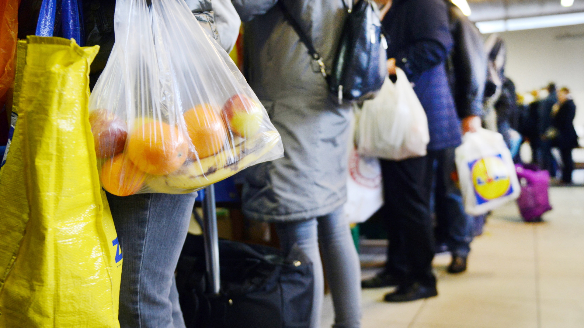 Themenbild Essensausgabe: Kunden stehen mit Tüten voller Lebensmittel während der Lebensmittel-Ausgabe in der Derendorfer Zionskirche. | dpa