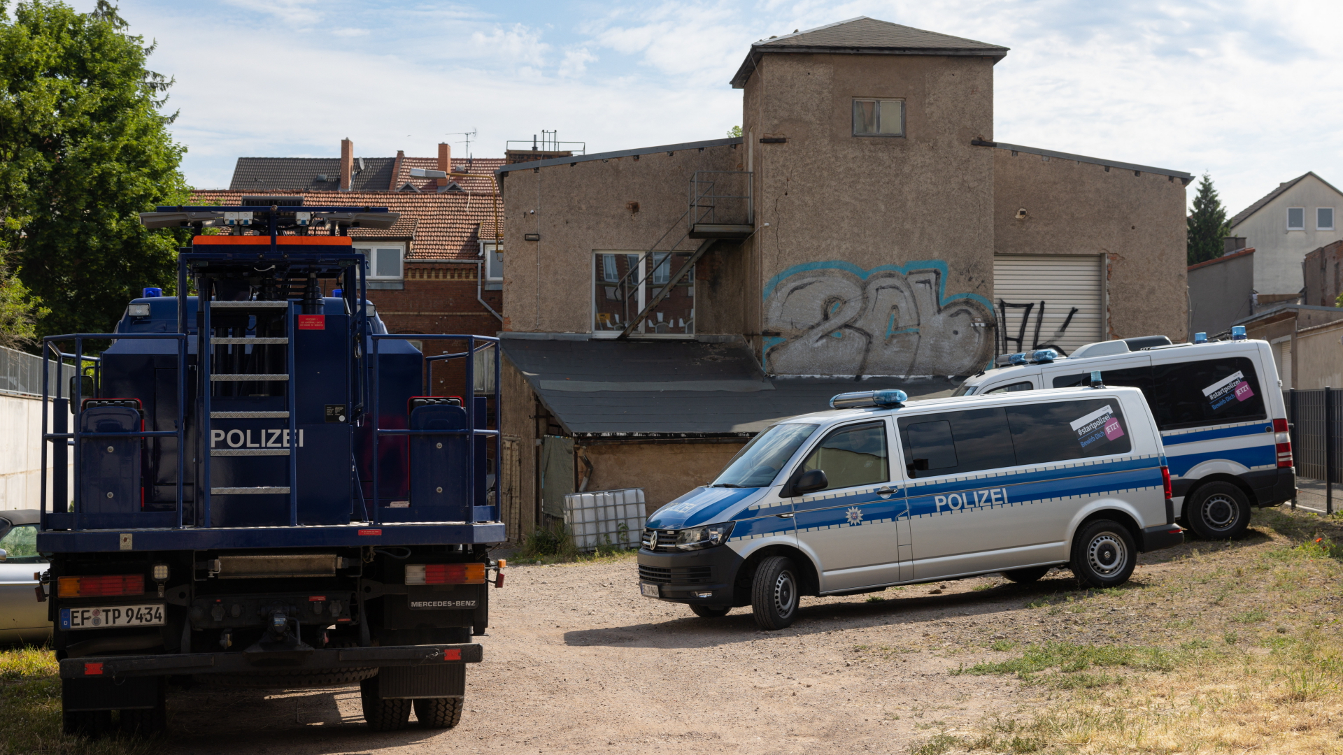 Polizizeiautos fahren nach einer Razzia in Thüringen von einem Fabrikgelände in Gotha | dpa