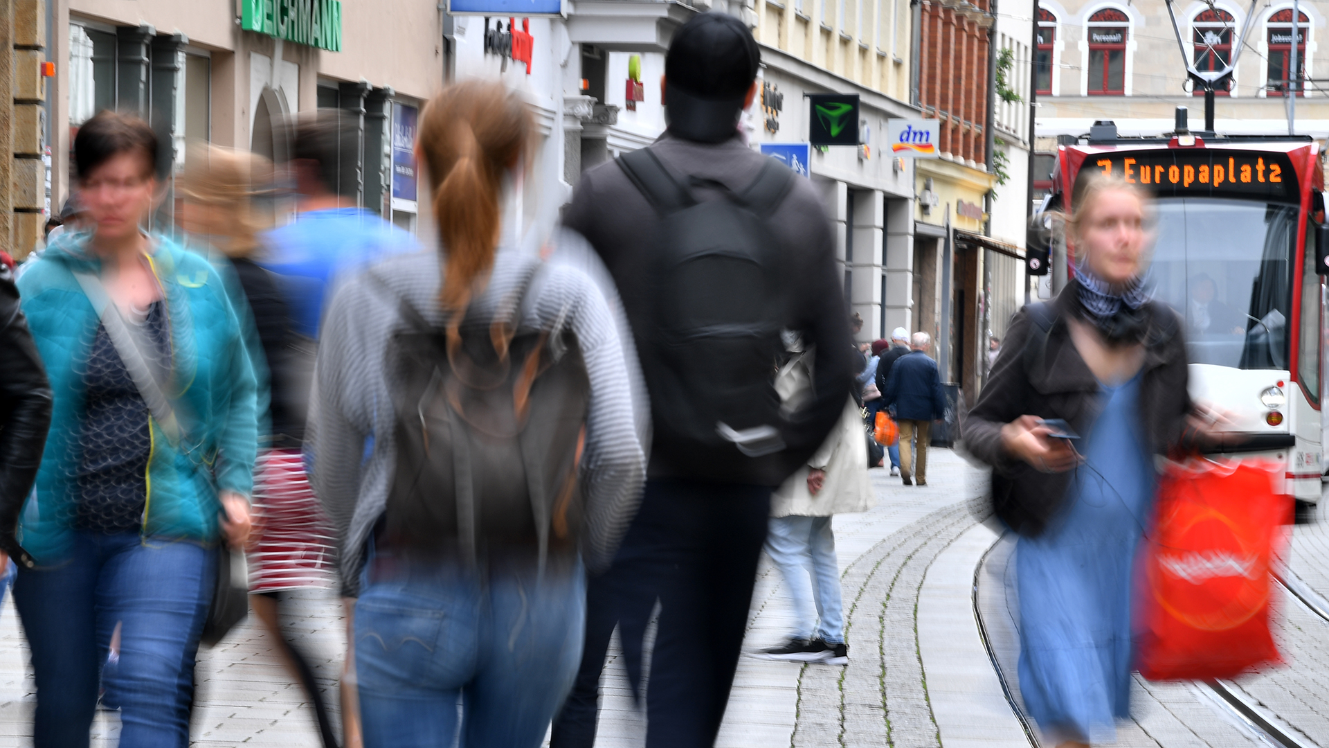 Passanten laufen im Stadtzentrum die Bahnhofstraße Erfurts entlang. | dpa