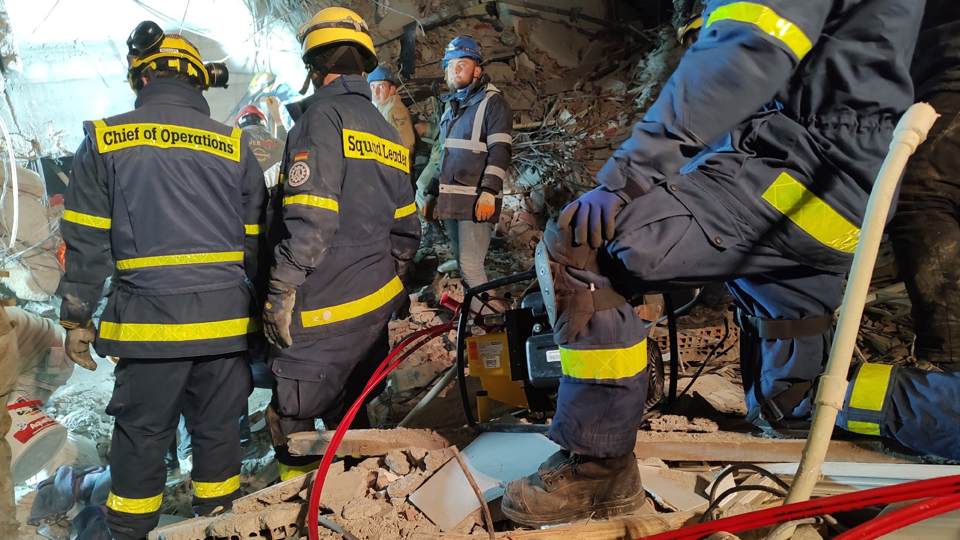 Einsatzkräfte des Technischen Hilfswerks (THW) stehen in den Trümmern eines eingestürzten Gebäudes. | dpa