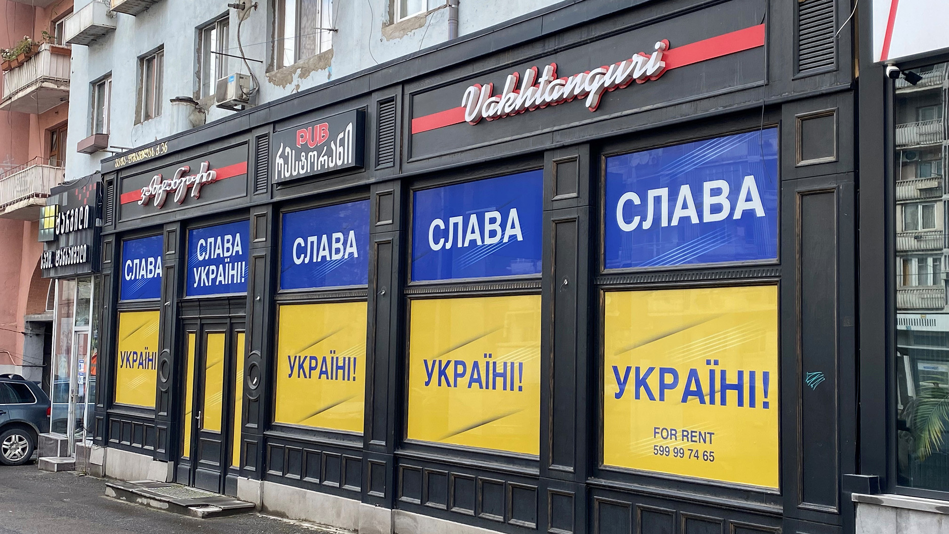 Die Fenster eines Pubs in Tiflis sind mit der ukrainischen Flagge und dem Schriftzug "Ruhm der Ukraine!" verdeckt. | Christina Nagel