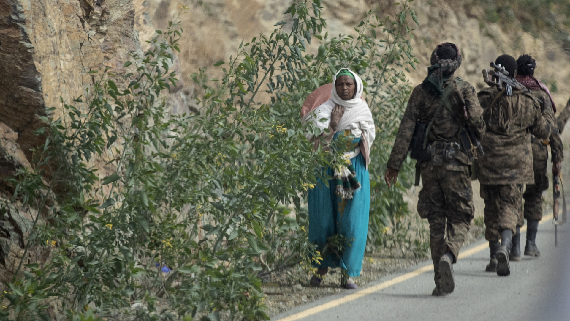 Eine Frau läuft an Soldaten in der Region Tigray vorbei