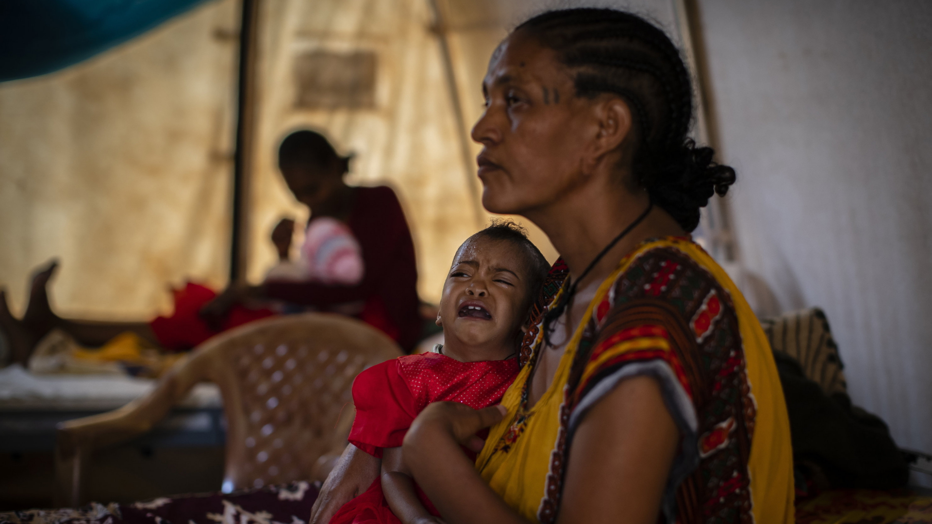 Eine Mutter in einem medizinischen Zelt Tigray hält ihr schreiendes Baby auf dem Arm. | AP