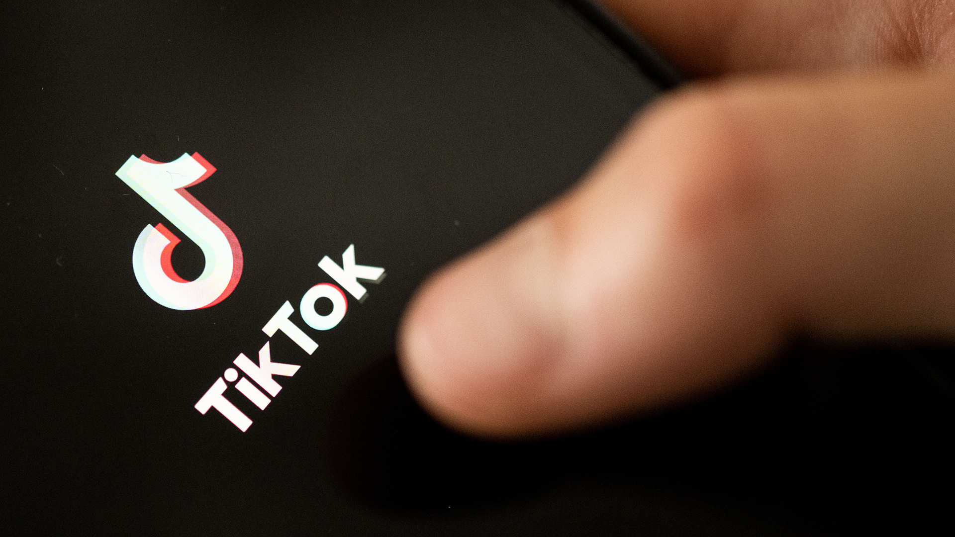 Ein Teenager tippt auf das TikTok-Logo auf einem Smartphone. | dpa