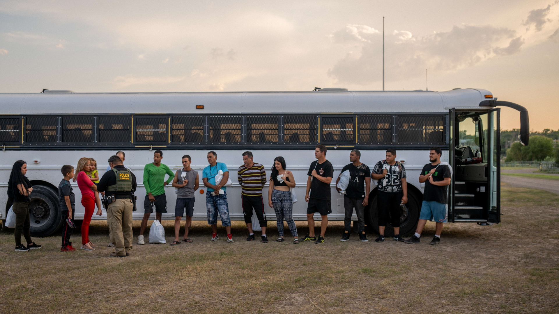 Migranten stehen vor einem Bus der US-amerikanischen Grenzpatrouille. | AFP
