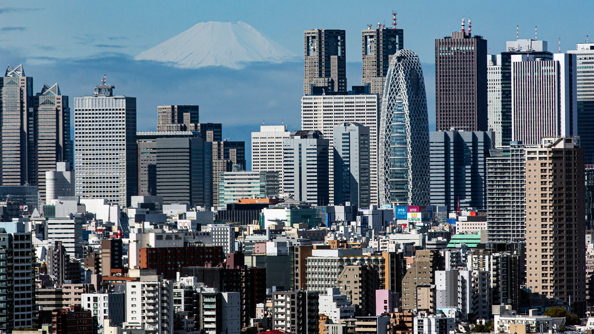 Der Berg Fuji erscheint hinter der Skyline von Wolkenkratzern im Einkaufs- und Geschäftsviertel Shinjuku in Tokio, Japan | AP