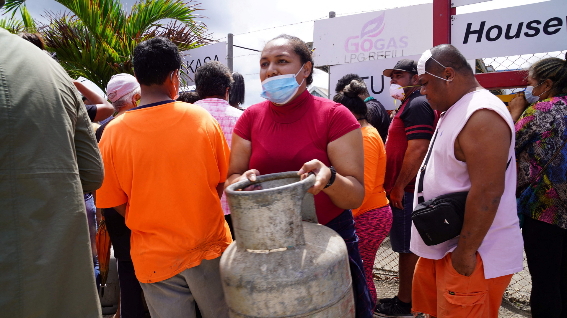 Eine Frau trägt einen nachgefüllten Gasbehälter in Tongas Hauptstadt Nuku'alofa. | AFP