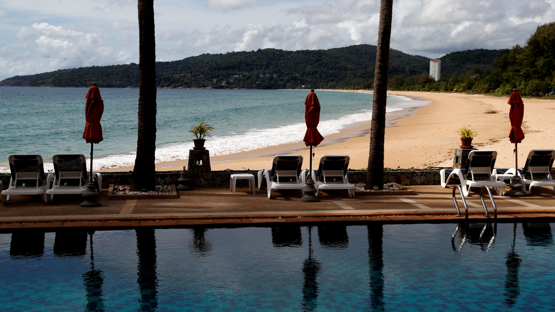 Verwaiste Liegestühle stehen an einem Pool mit Strandblick in einem Hotel in Phuket. | REUTERS