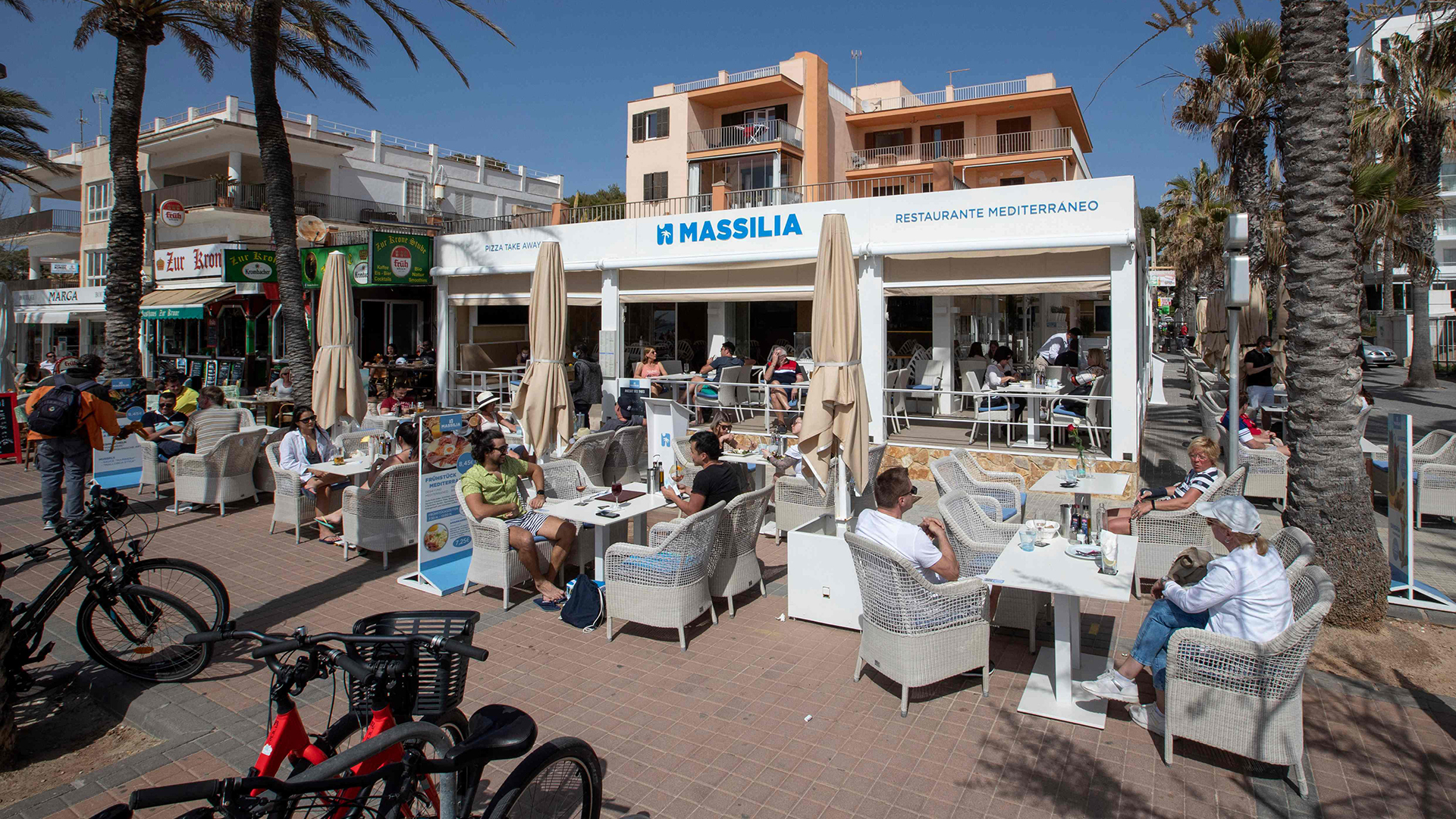Touristen sitzen auf der Terrasse eines Restaurants auf Mallorca (Spanien).