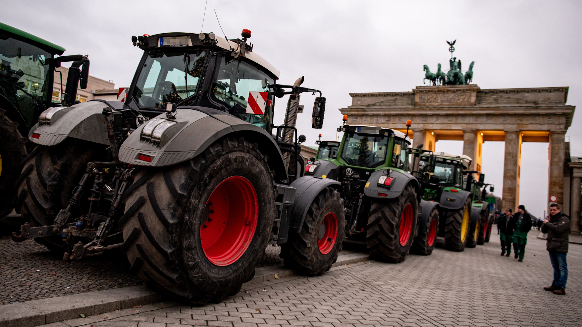Traktoren stehen aufgereiht vor dem Brandenburger Tor in Berlin